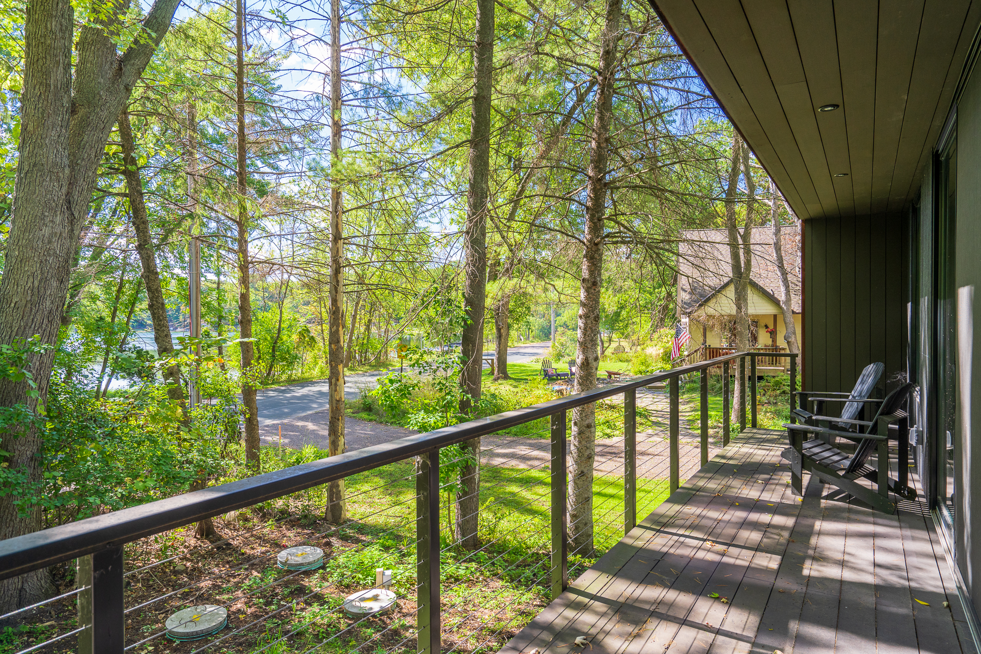 A peaceful balcony view surrounded by trees and a winding road.