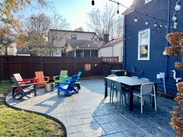 A vibrant outdoor patio with colorful Adirondack chairs and a dining area.