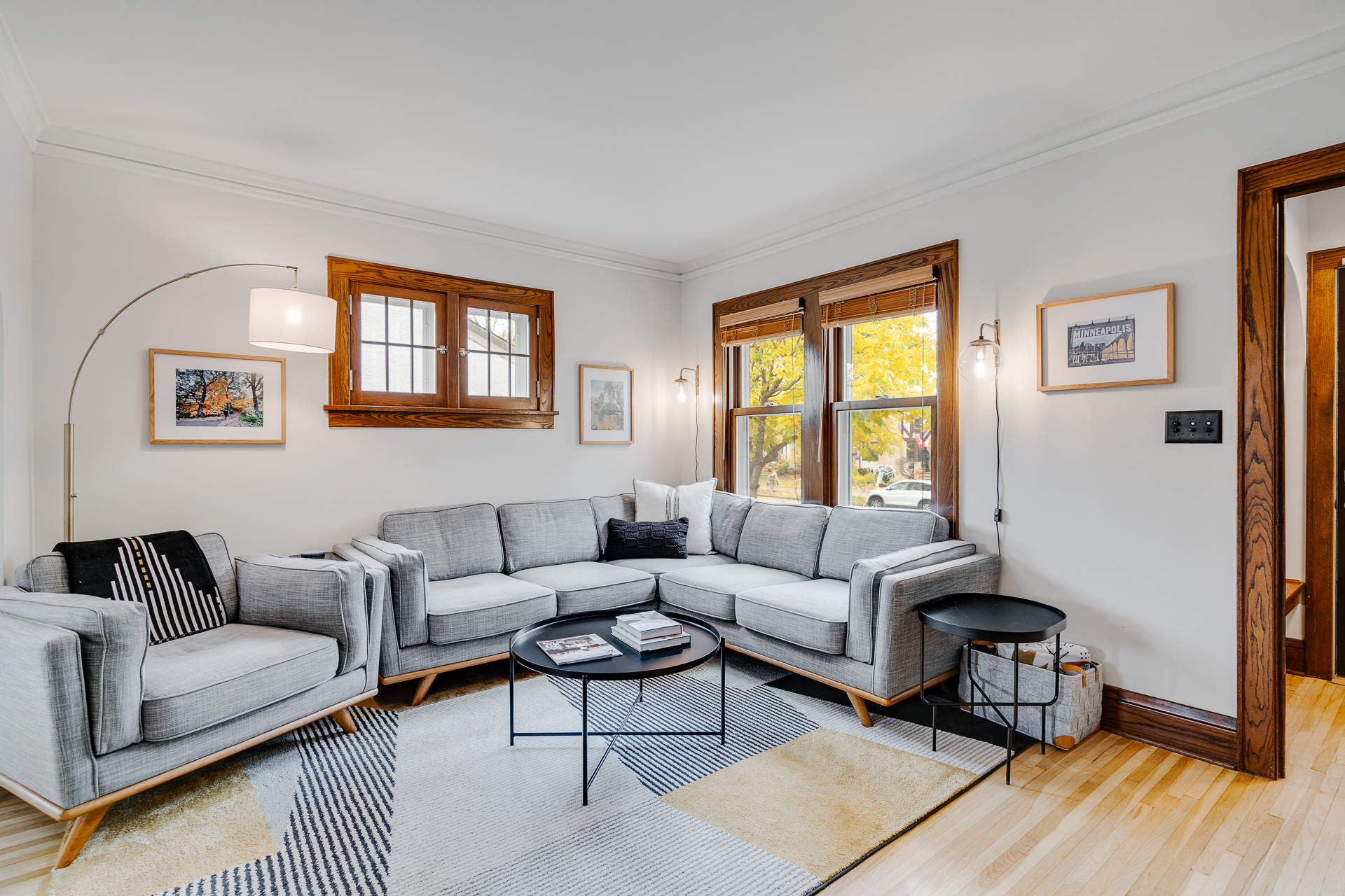 A modern and welcoming living room with a stylish gray sectional couch and abundant natural light.