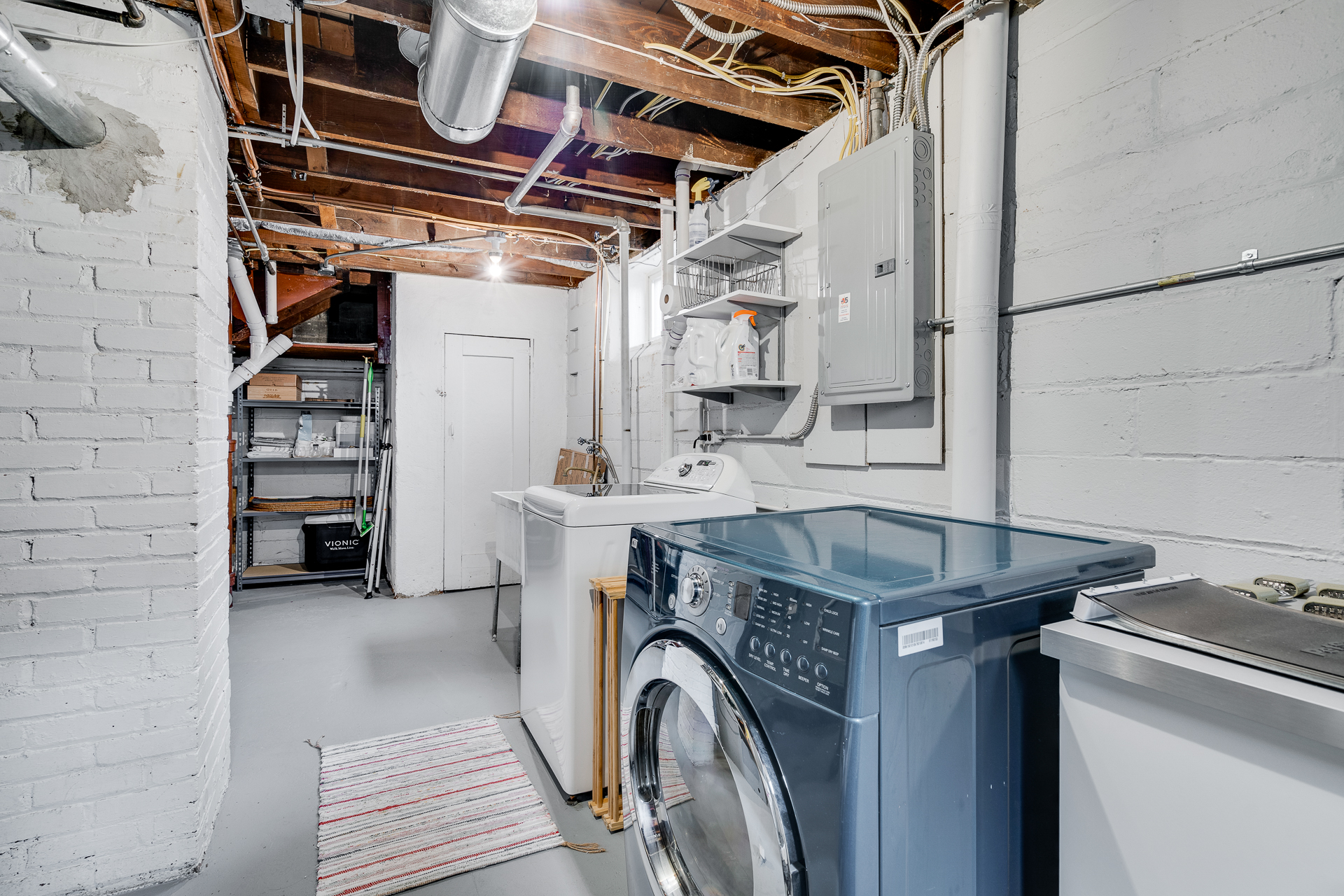 Organized laundry room in a basement with modern appliances and practical storage.