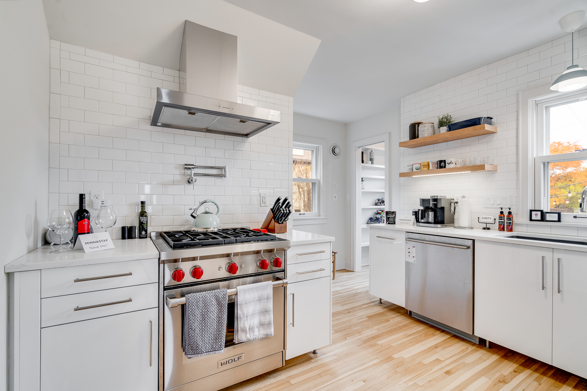 A contemporary kitchen featuring sleek white cabinetry and a high-end stove.