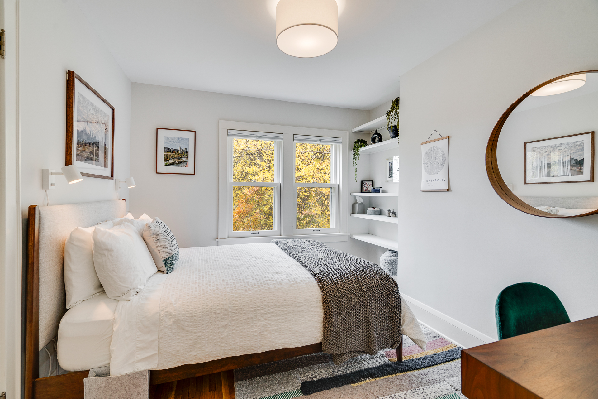 A cozy bedroom with modern decor and autumn views.