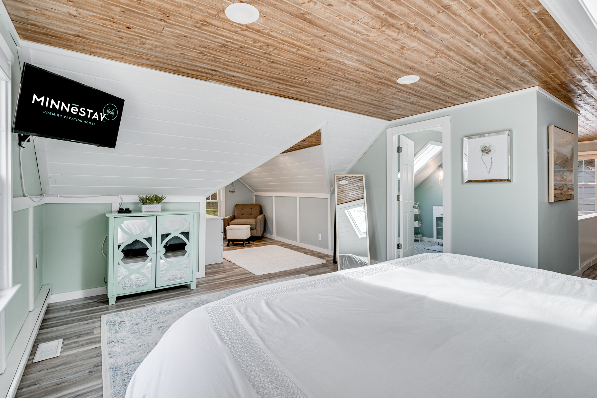 A cozy attic bedroom with sloped ceilings and modern amenities.