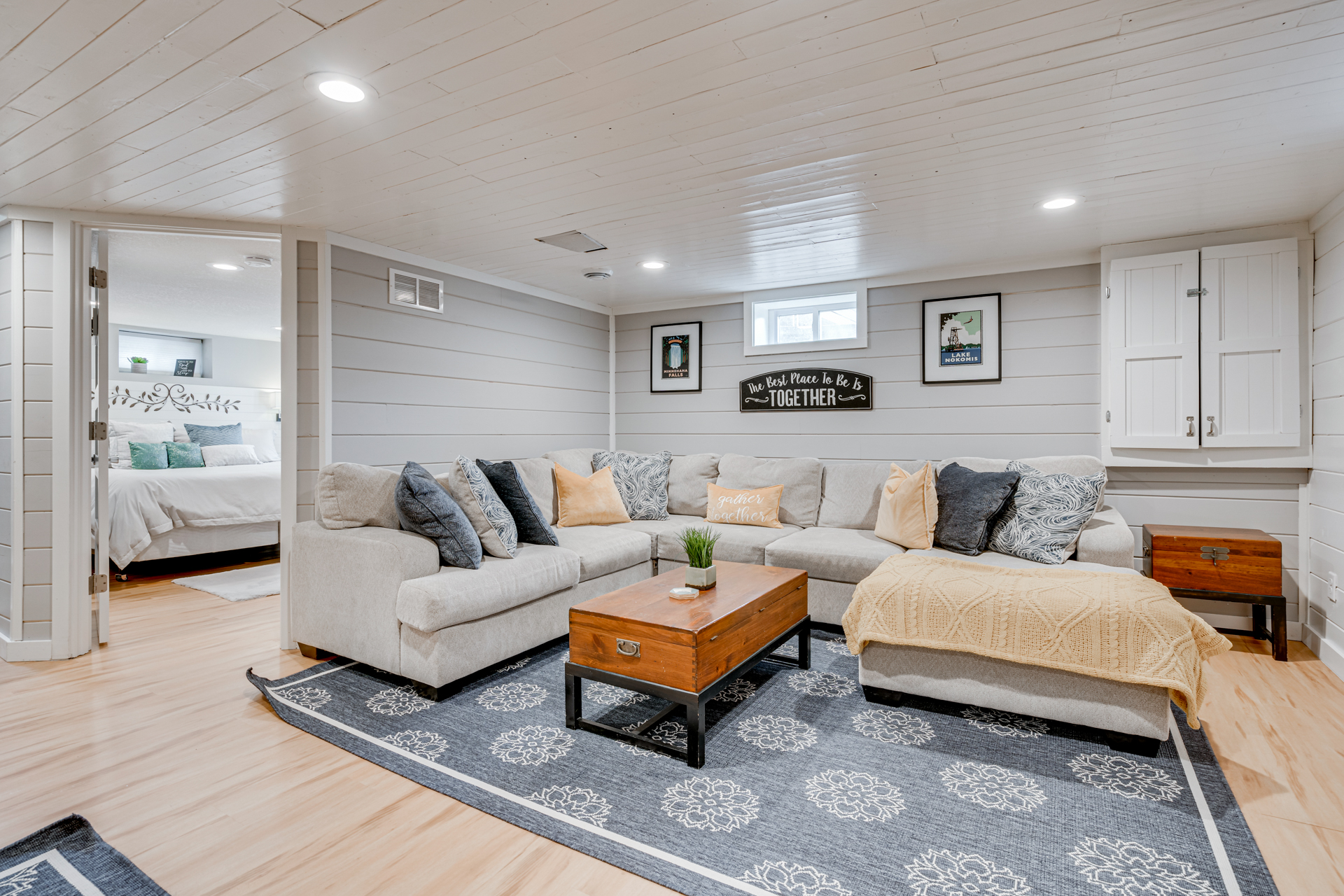 Cozy basement living area with a sectional sofa and rustic decor.