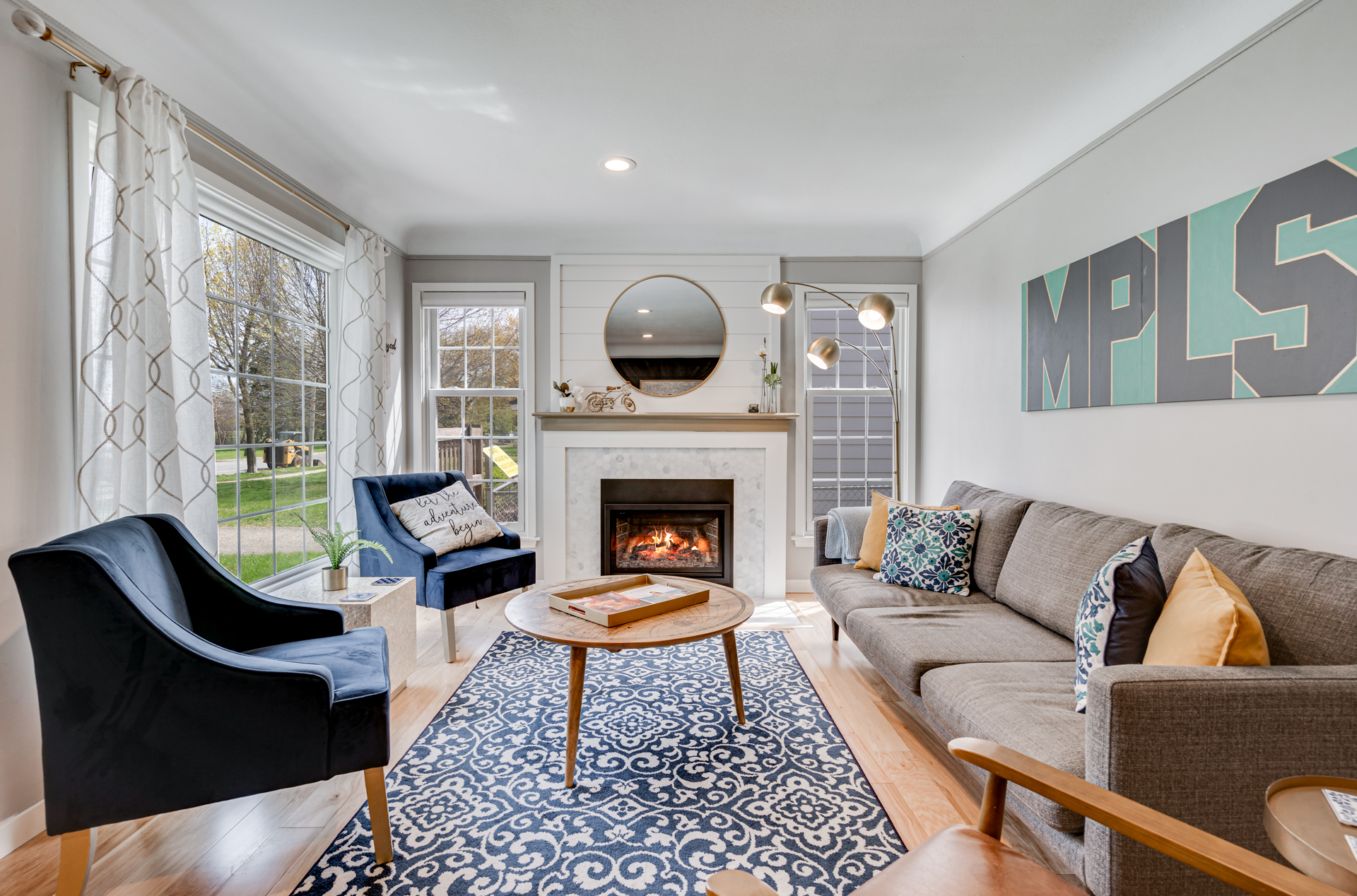 A cozy modern living room with navy accents and a stylish fireplace.