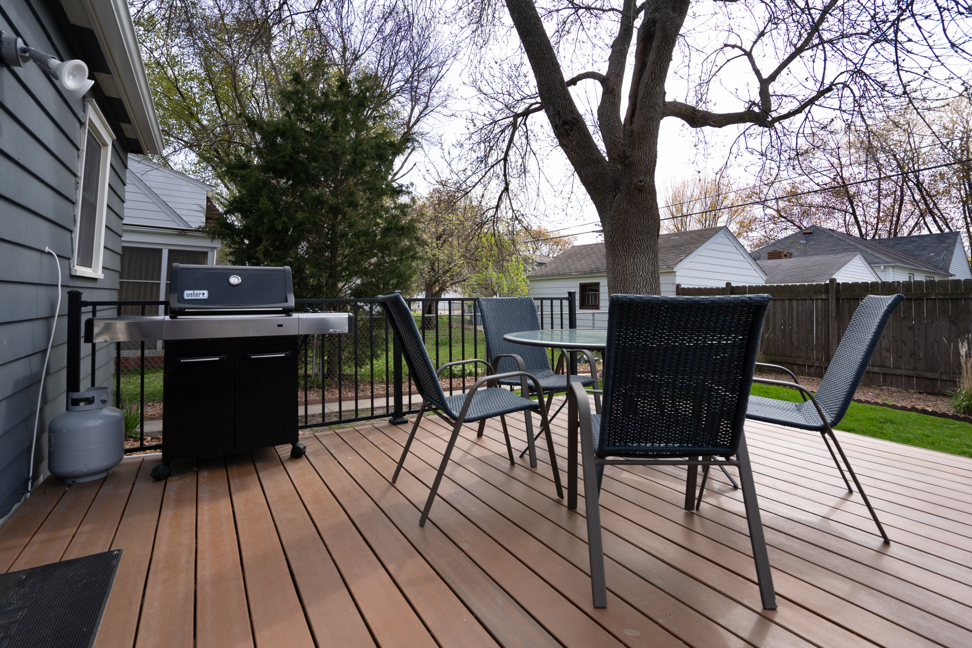 A modern outdoor deck with a grill and seating area.