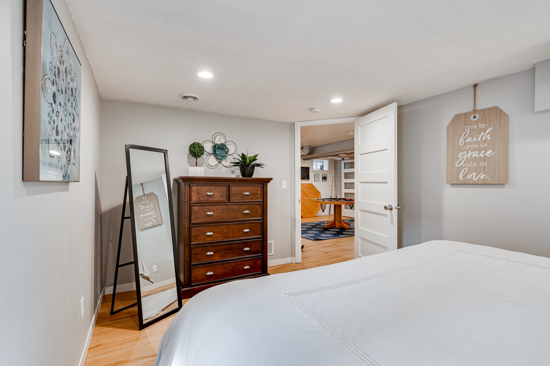 A cozy bedroom with elegant decor and a glimpse of a playful area beyond.