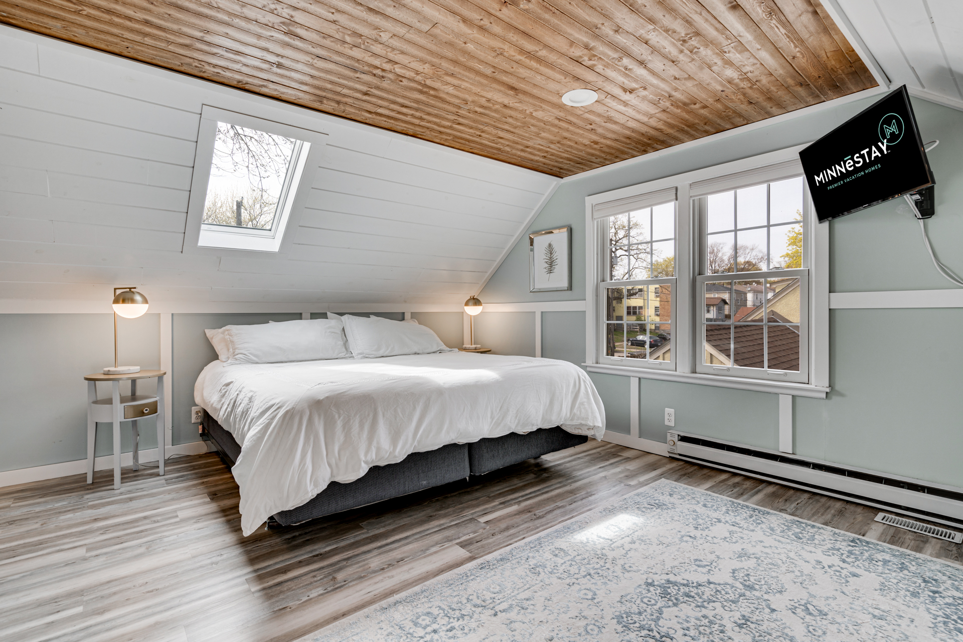 A cozy, modern bedroom with a sloped ceiling and chic decor.