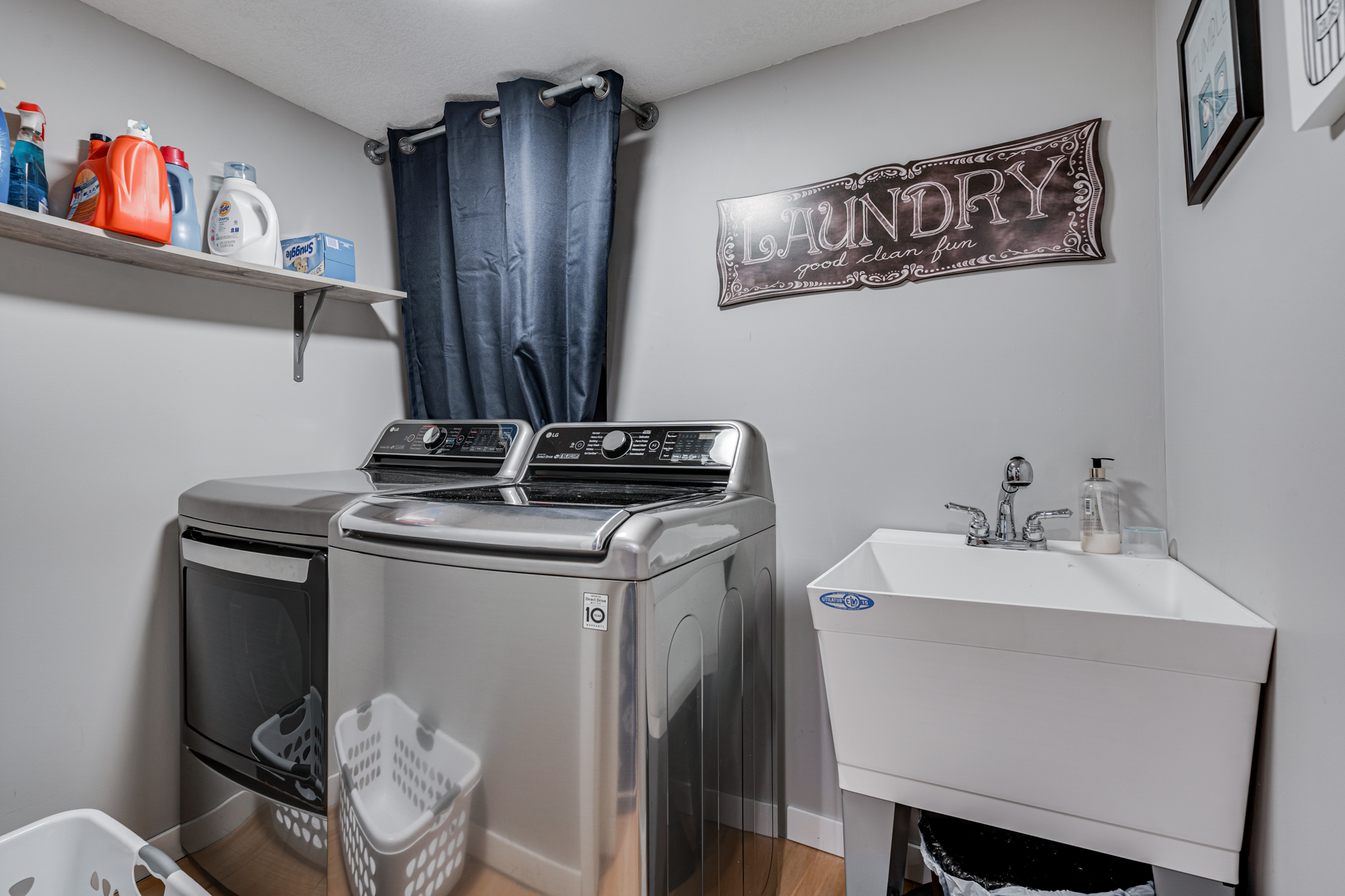 A modern laundry room with sleek appliances and a decorative touch.
