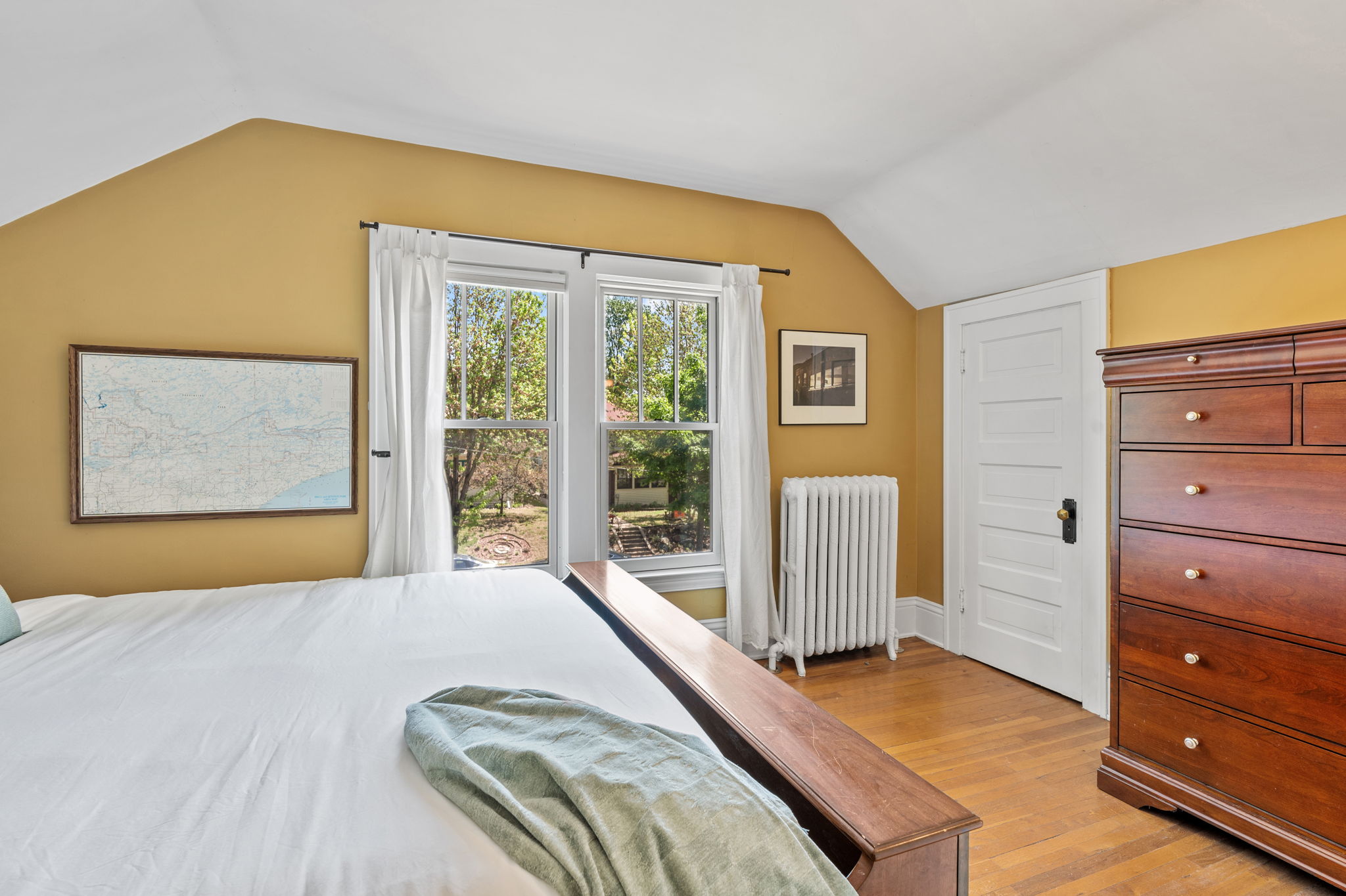 A serene bedroom with warm yellow walls and elegant decor.