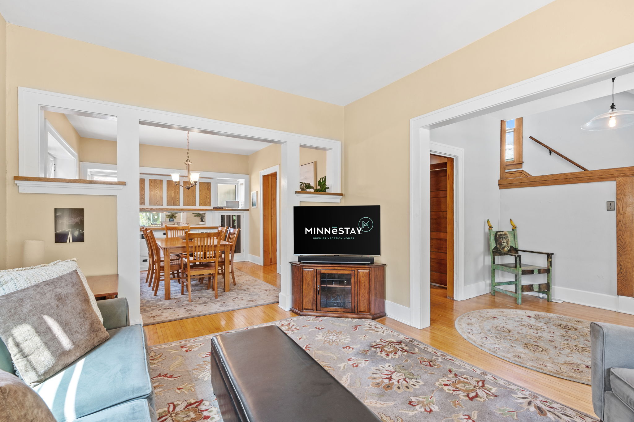 A cozy living area seamlessly transitions to a bright dining space with wooden furnishings.