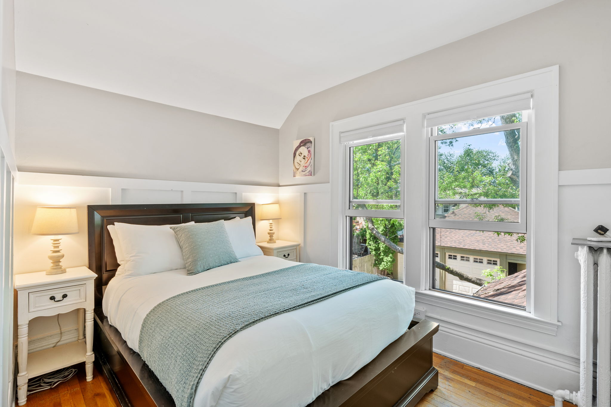 A serene and inviting bedroom with natural light and tasteful decor.