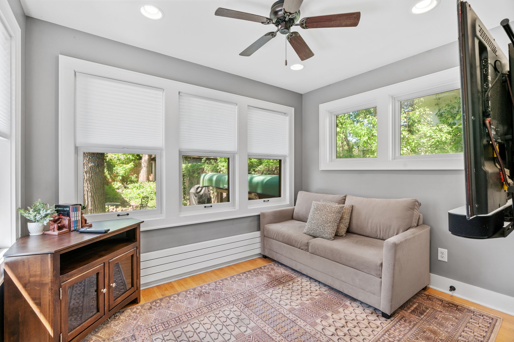 A cozy sunroom featuring abundant sunlight and a modern design.