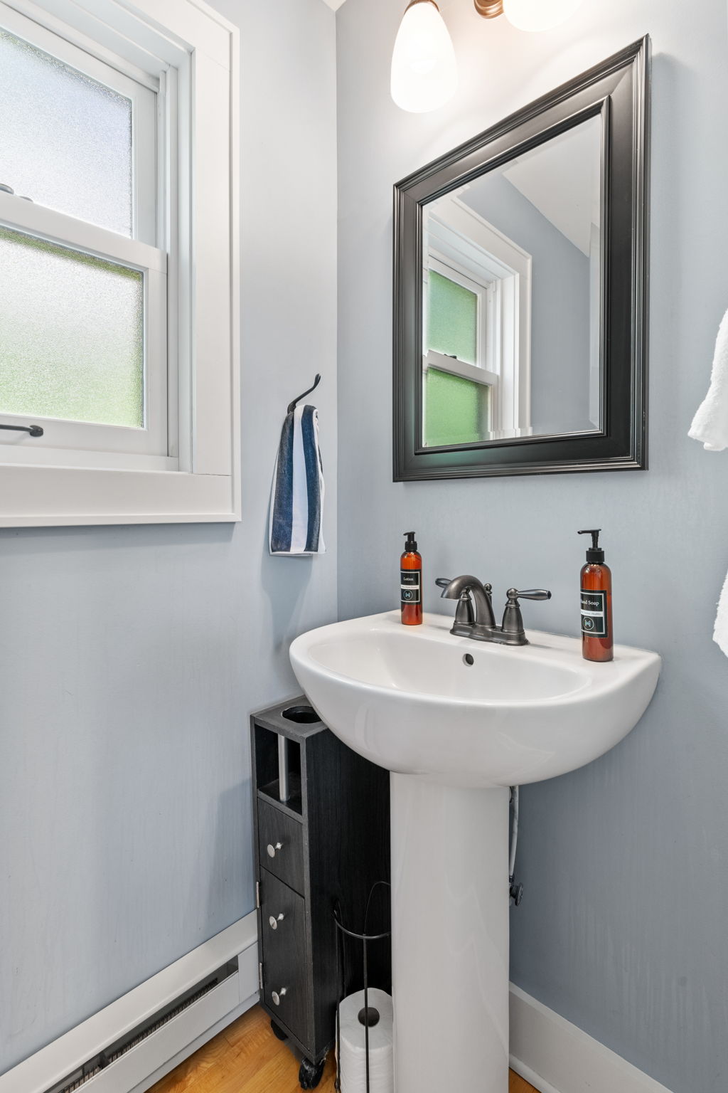 A modern small bathroom featuring a sleek pedestal sink and contemporary decor.