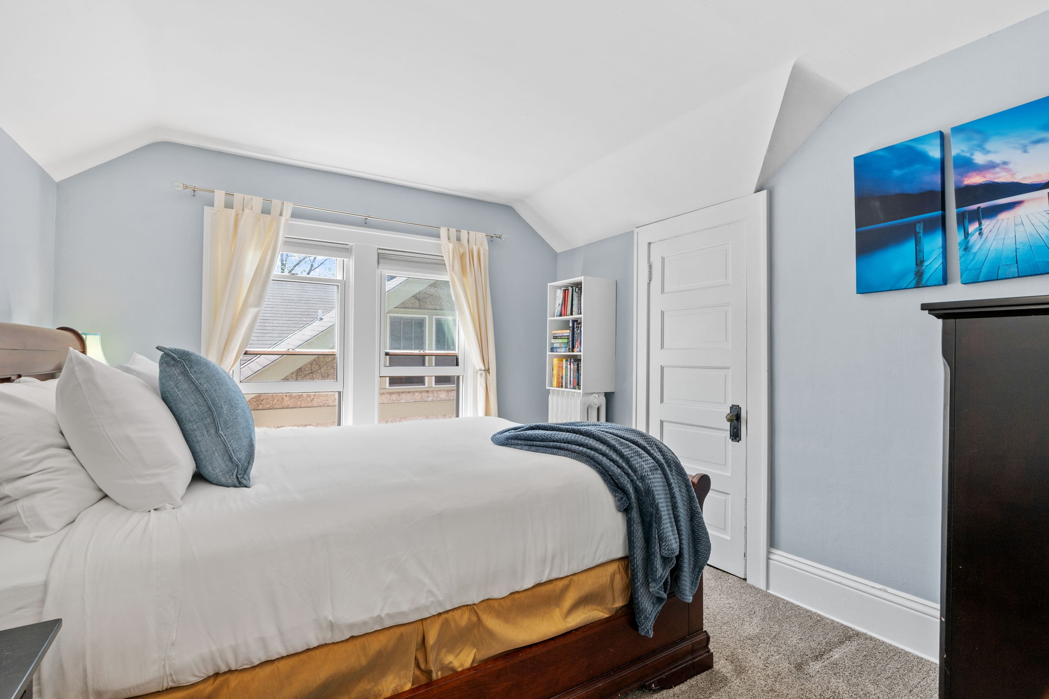 A serene bedroom with soft blue walls and cozy furnishings.