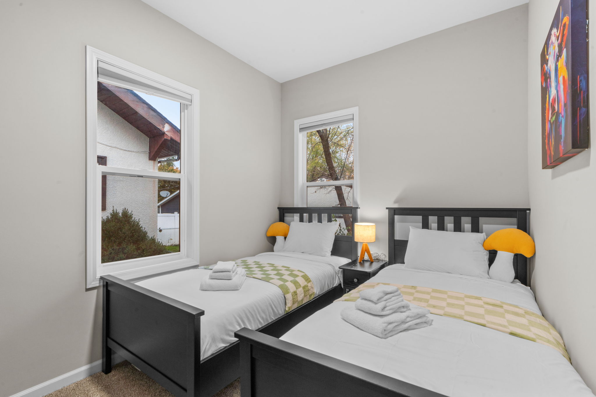 A bright and cozy bedroom with twin beds and playful decor.