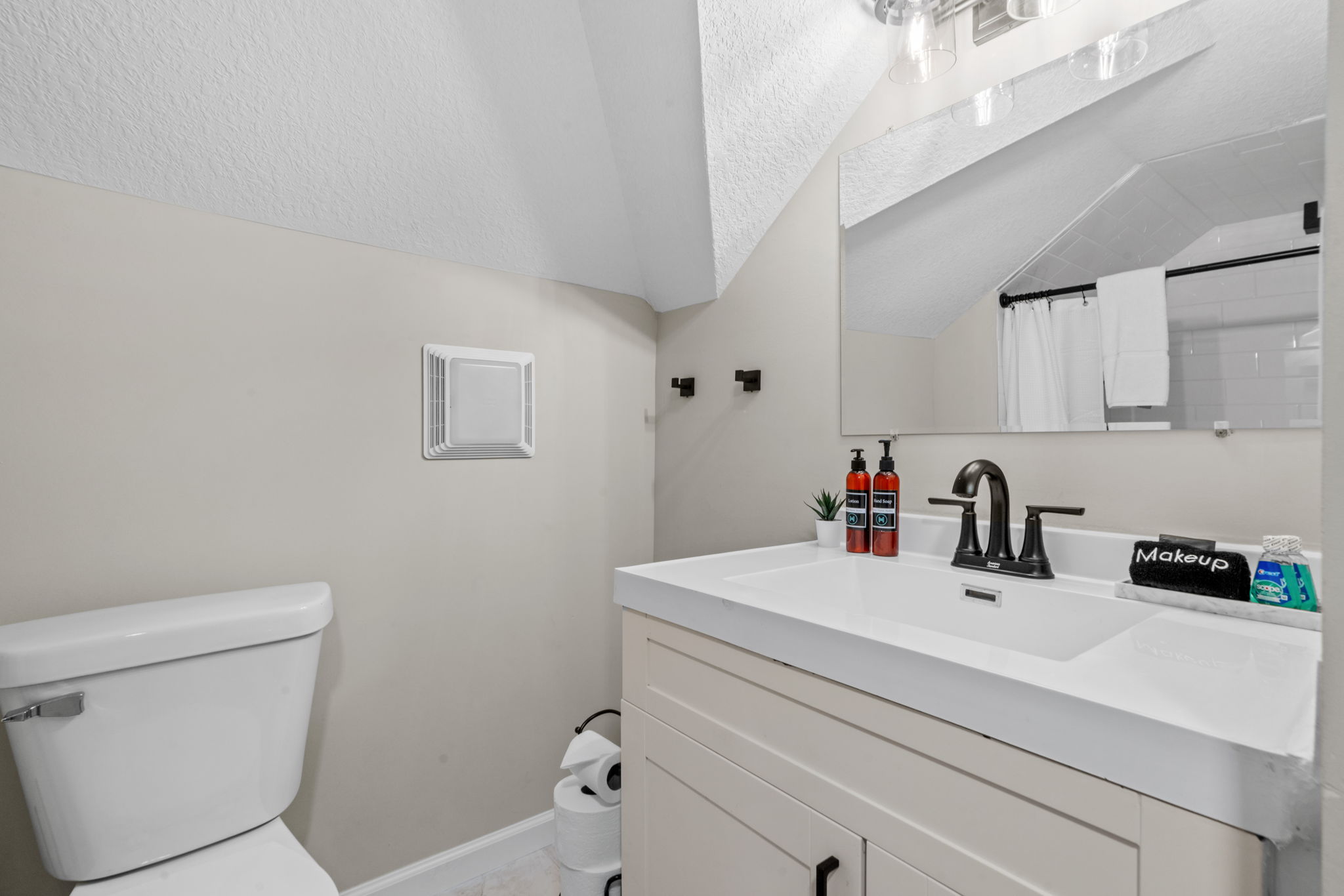 A cozy attic bathroom featuring modern amenities and warm colors.