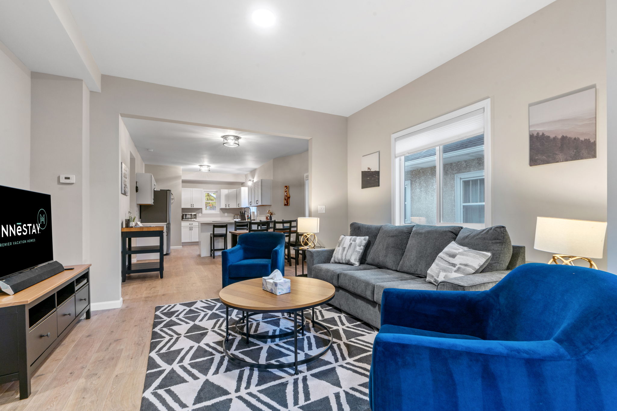 Modern living room with stylish decor and an open kitchen.