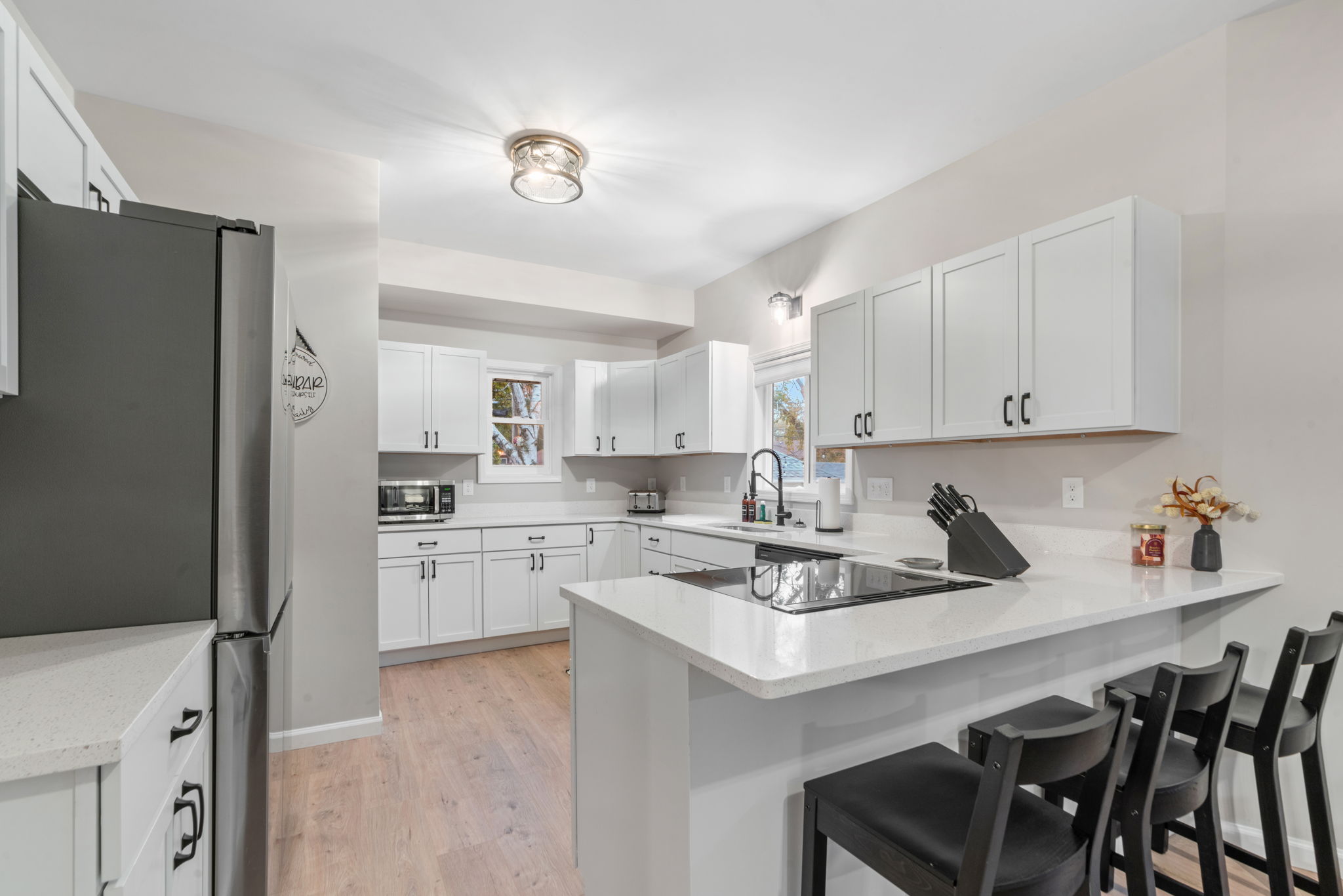 A modern kitchen featuring bright white cabinetry and sleek finishes.
