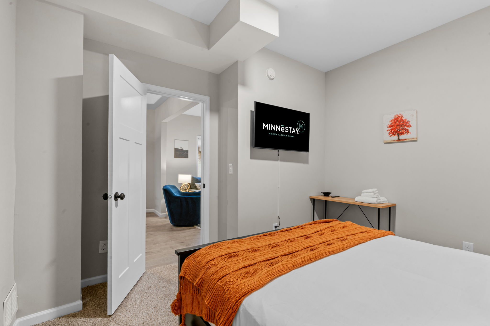 A cozy bedroom featuring modern amenities and a warm color palette.