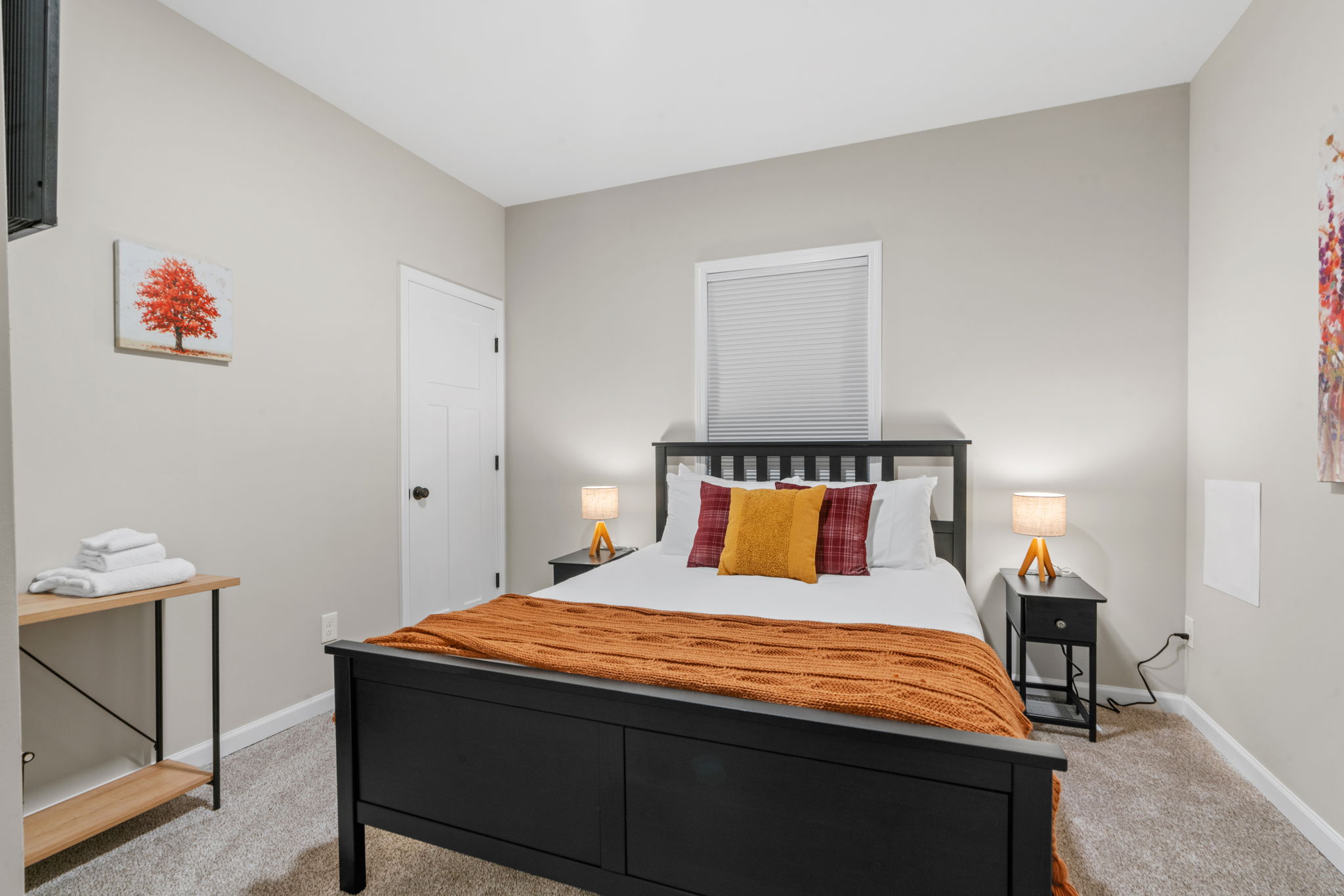 A cozy and inviting bedroom featuring a black bed frame and warm accents.