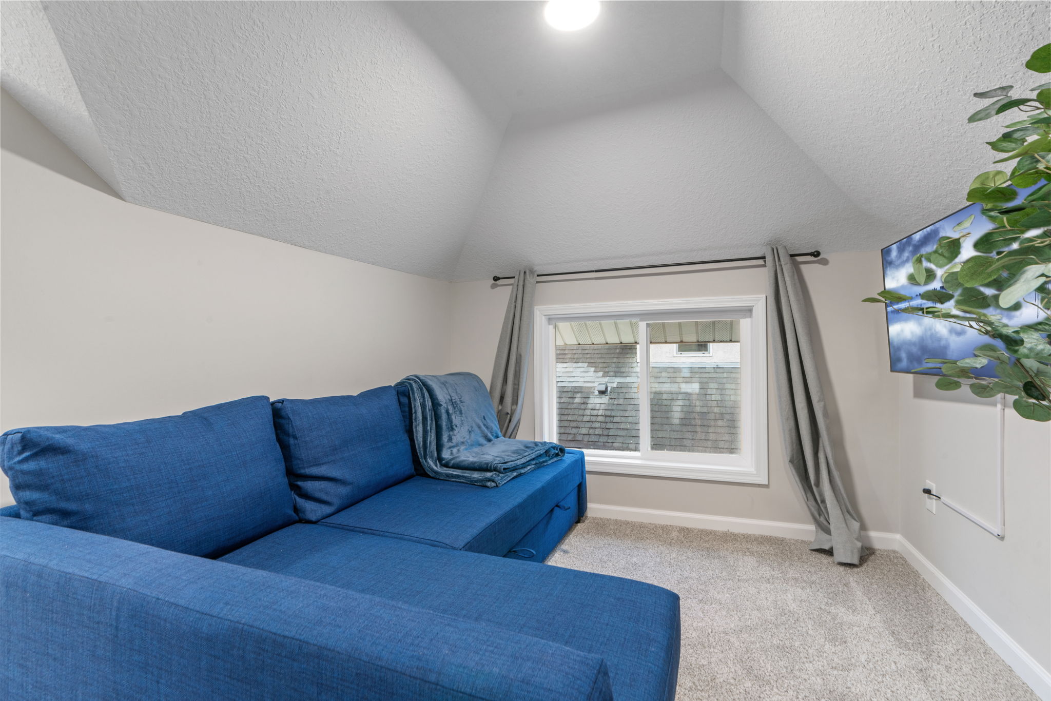 A cozy nook with a blue sectional couch and natural light.