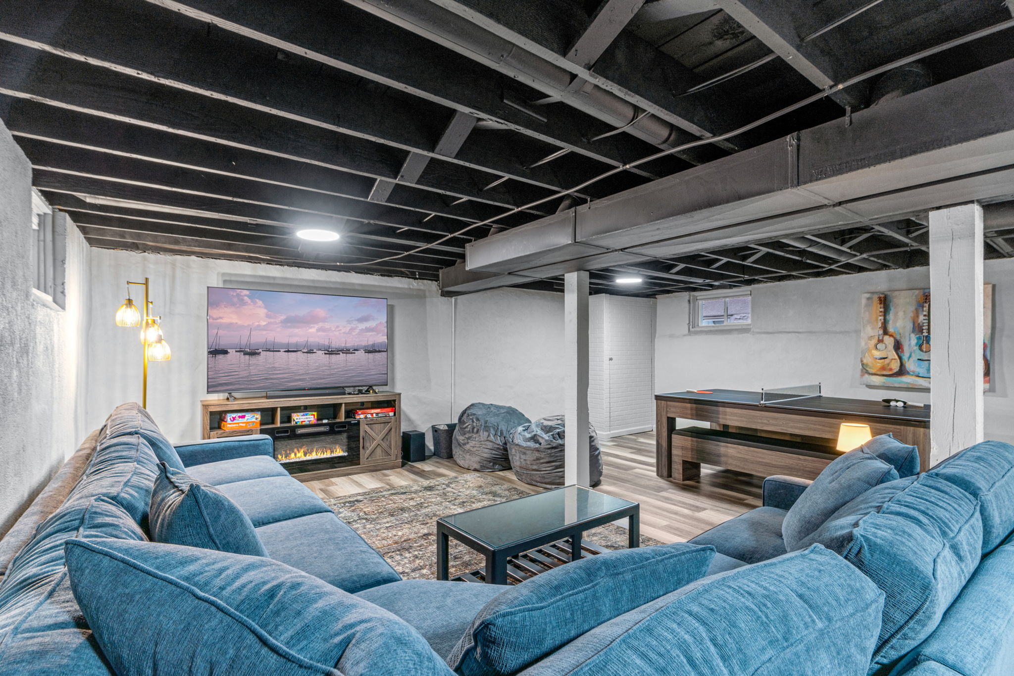 Cozy and modern basement living room with a large sectional sofa and entertainment setup.
