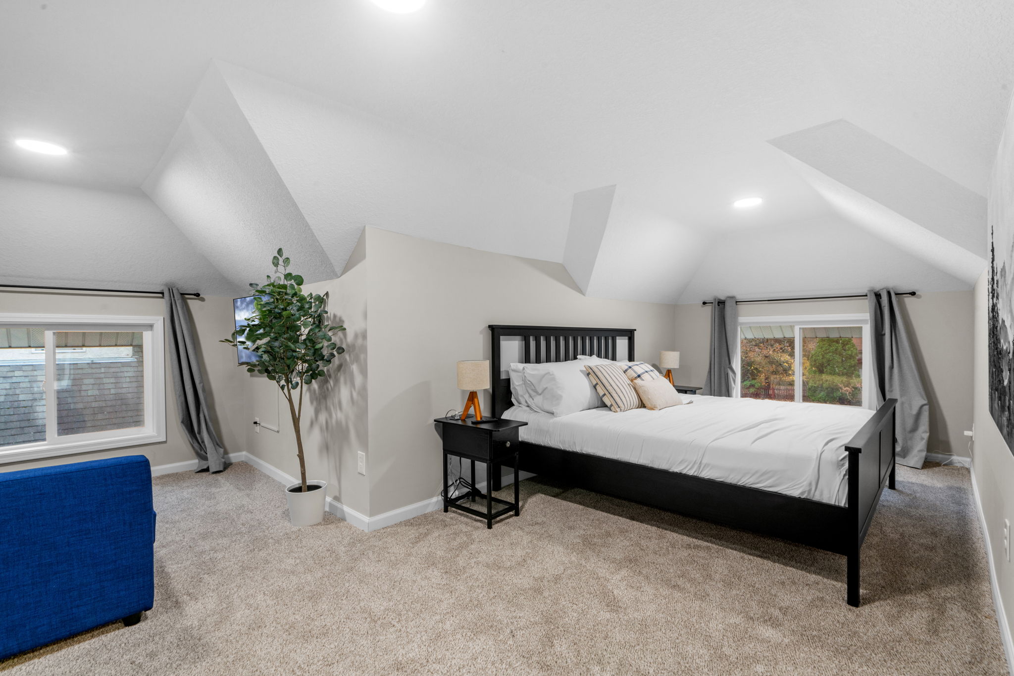 A cozy attic bedroom with modern decor and sloped ceilings.