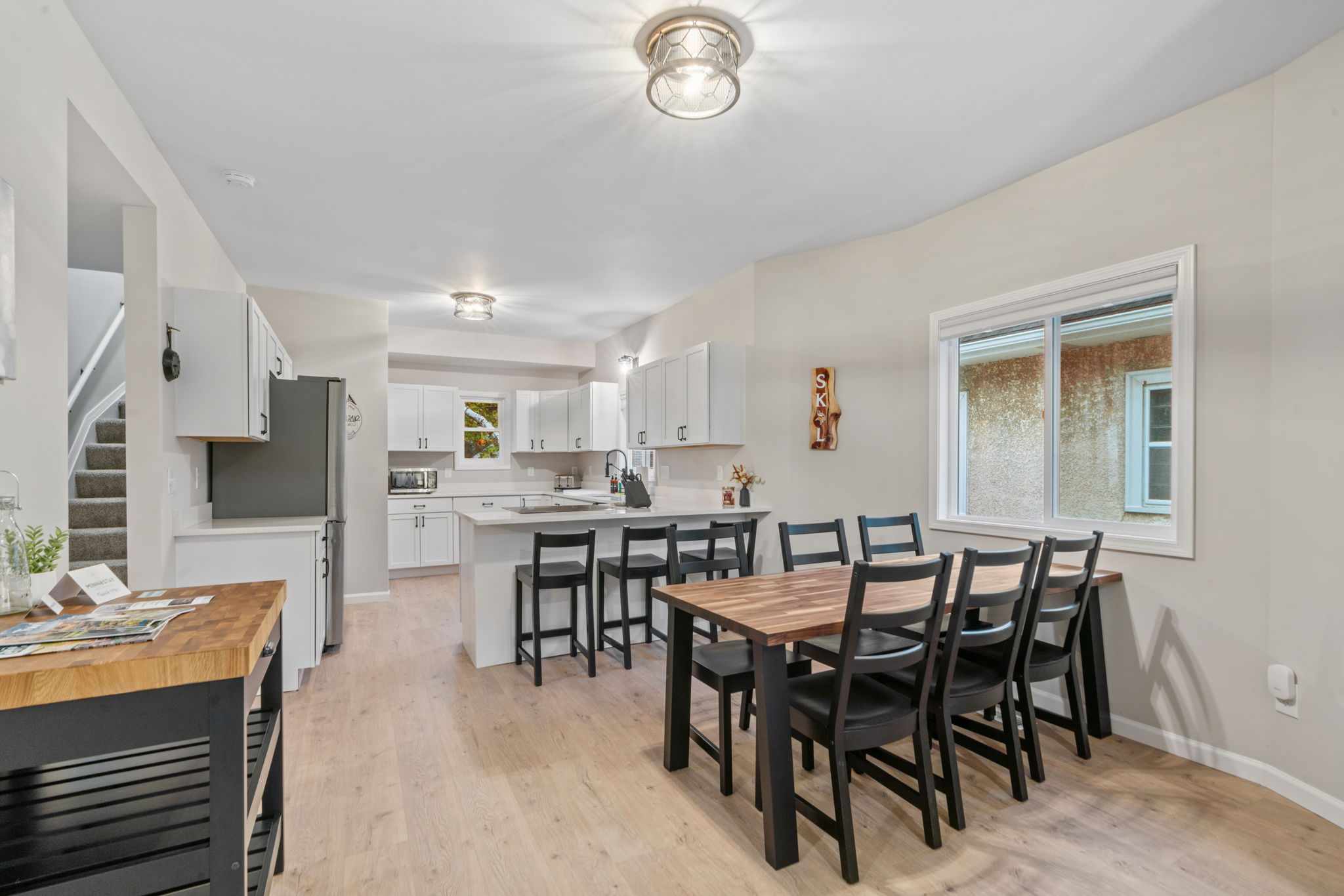 Cozy and modern kitchen with dining area featuring a wooden table and stylish decor.