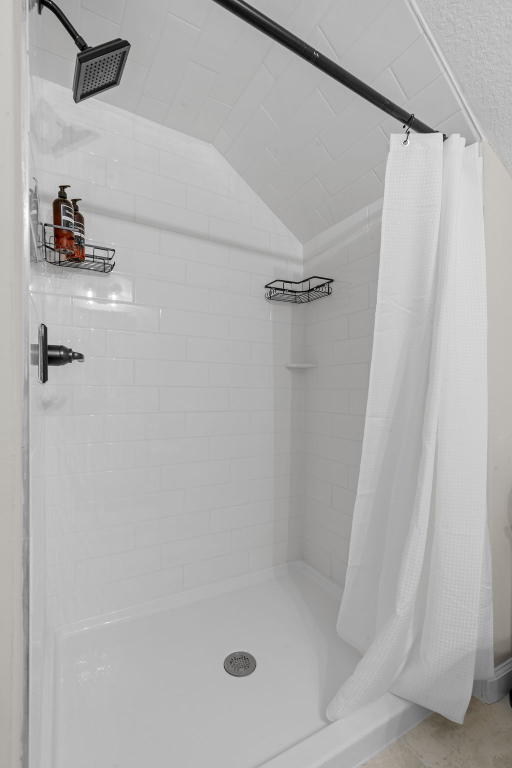 A modern, clean shower space featuring subway tiles and minimalistic design elements.