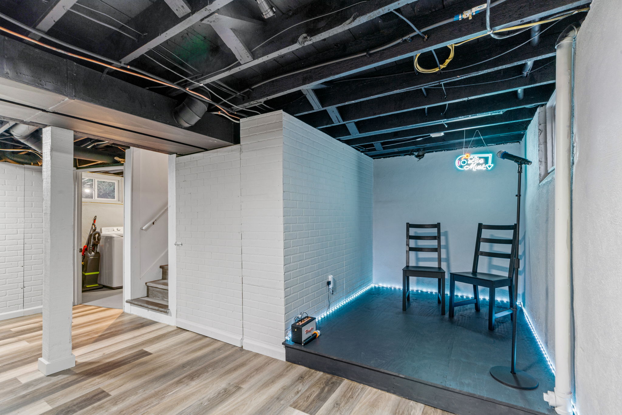 A stylish basement performance area with modern decor and lighting.