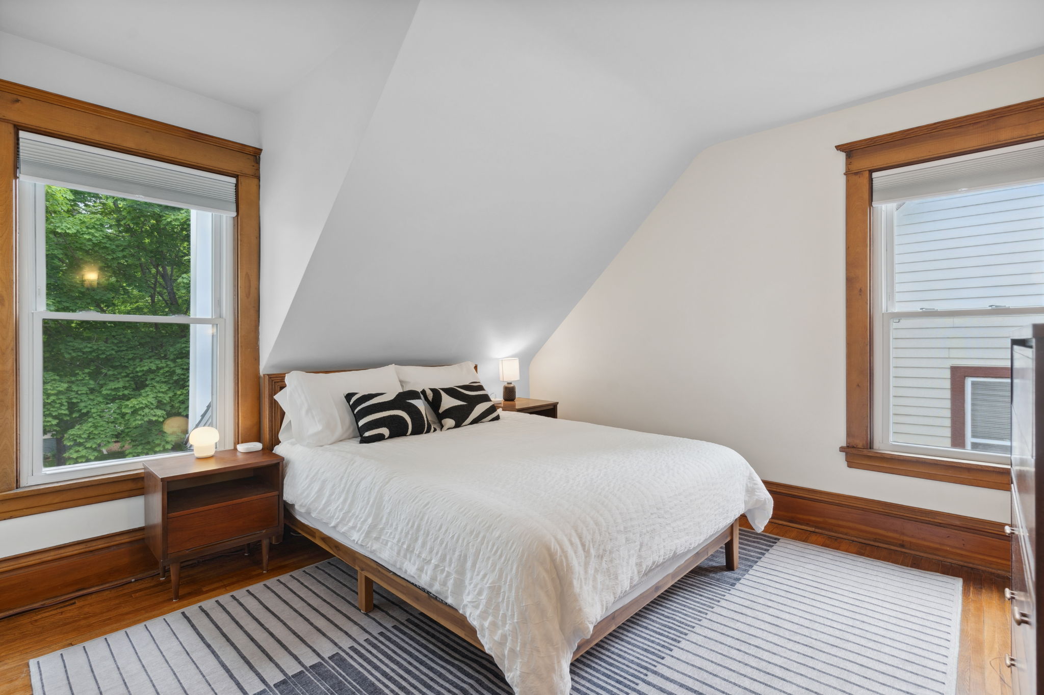 Cozy and stylish bedroom with sloped ceiling and natural light.