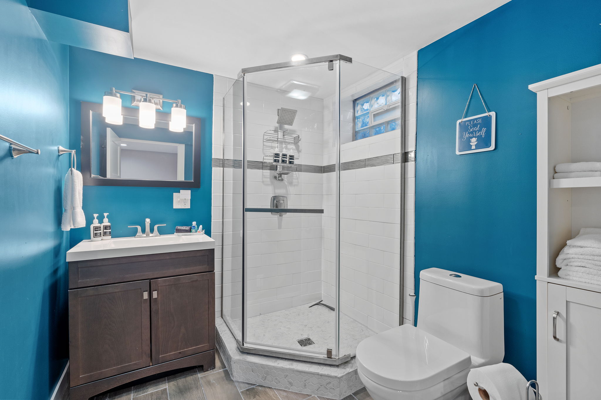 A modern bathroom with turquoise walls and sleek fixtures.