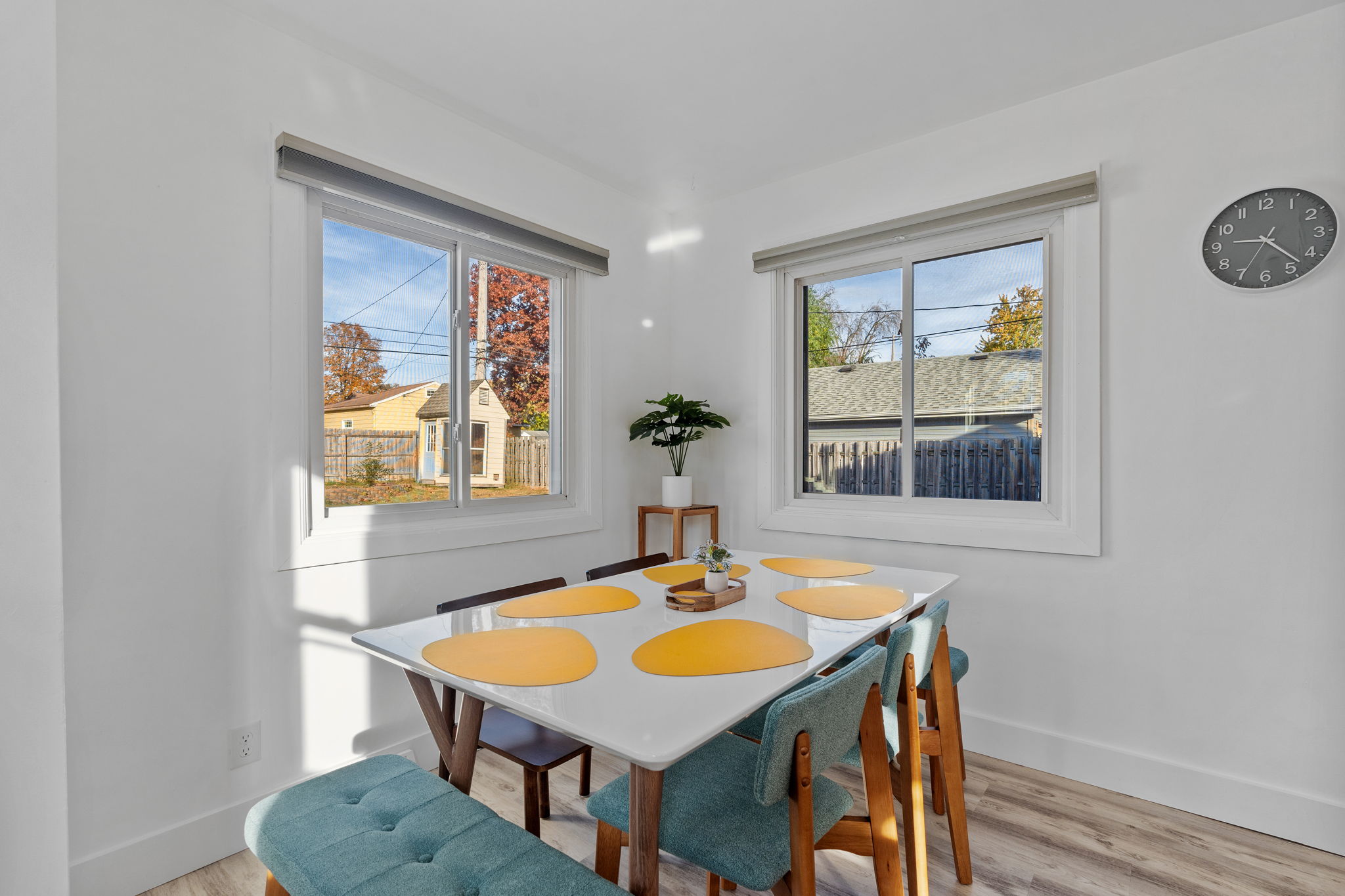 A modern dining nook with bright windows and colorful decor.