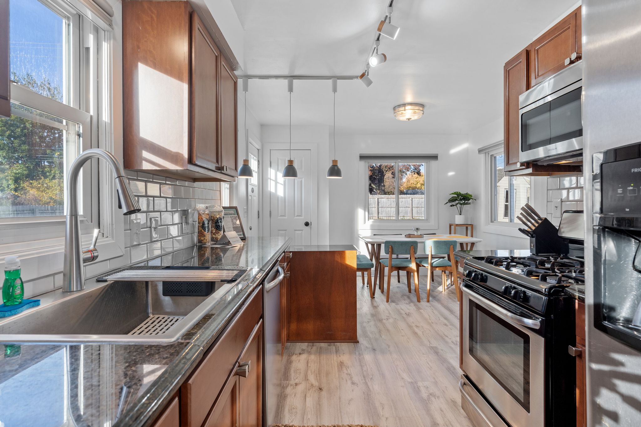 A contemporary kitchen seamlessly flows into a cozy dining area, illuminated by natural light.