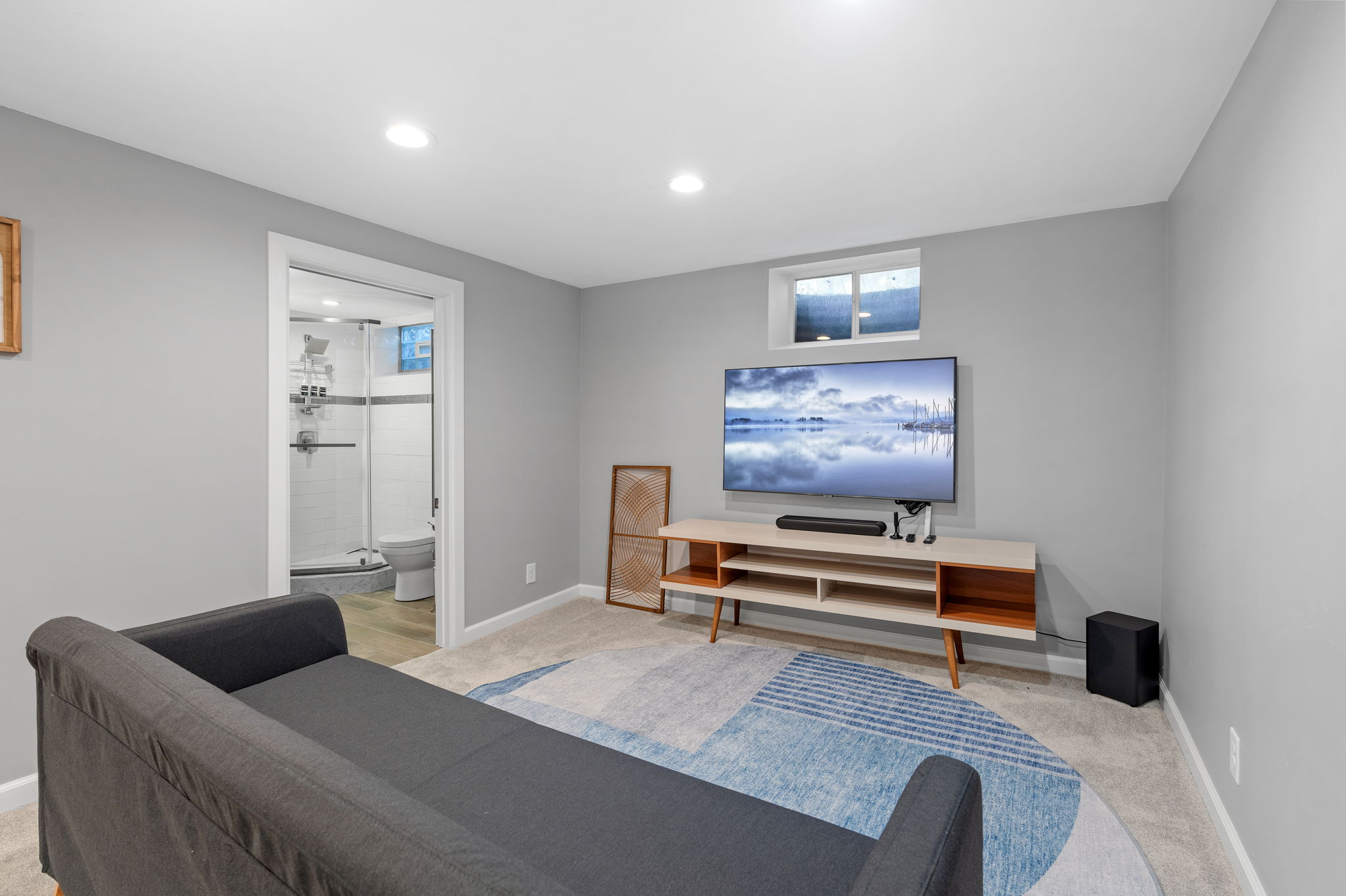 A modern living room featuring a sleek TV setup and cozy furniture.