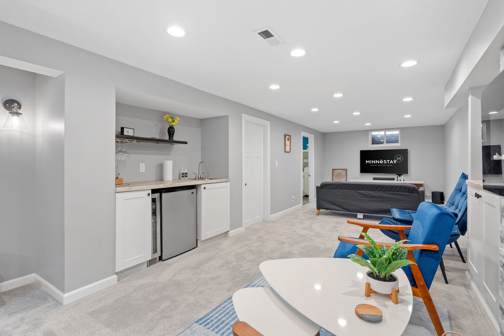 Modern and cozy basement living area with kitchenette and stylish seating.