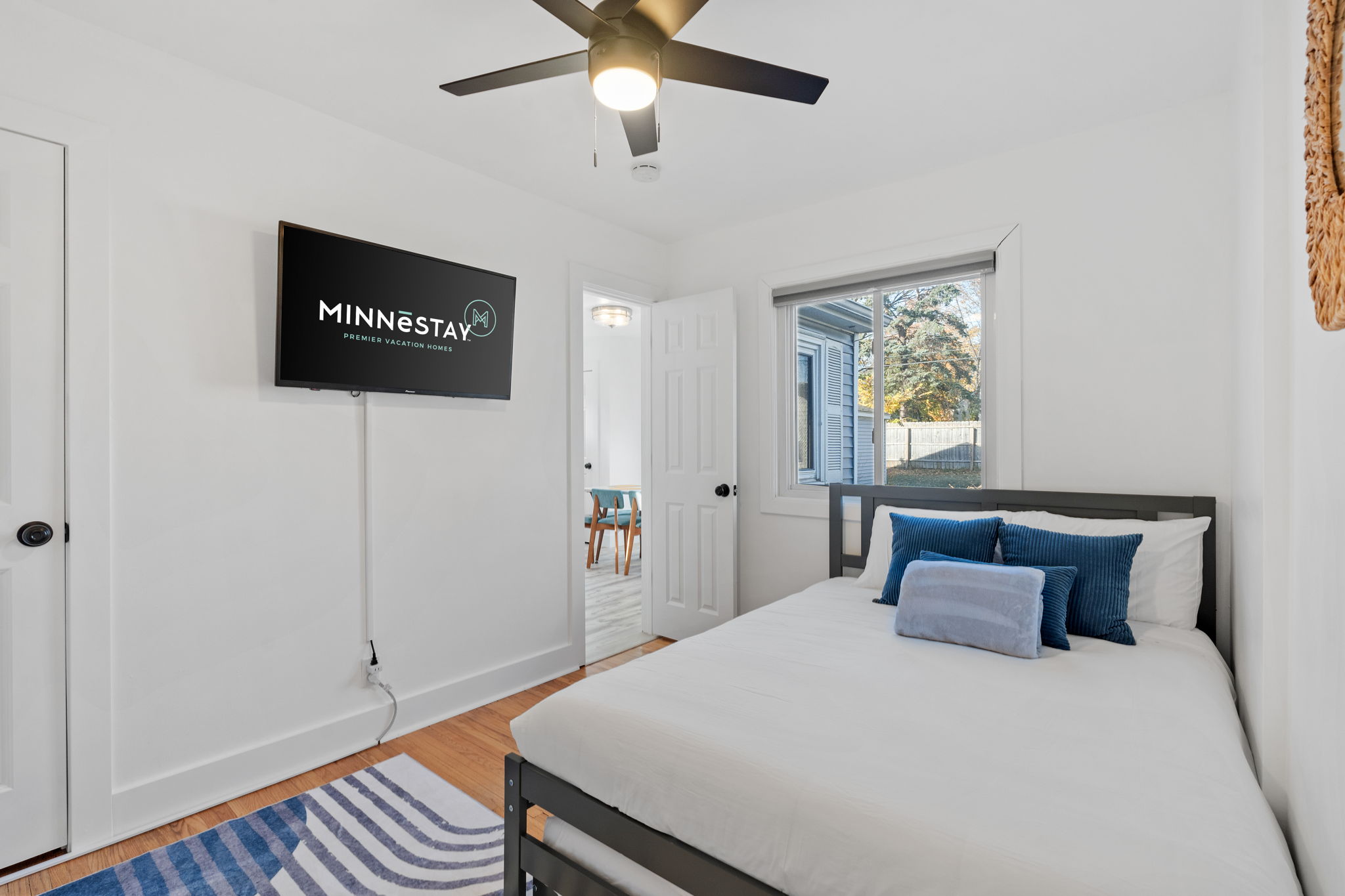 A bright and modern bedroom showcasing a minimalist aesthetic with blue accents.