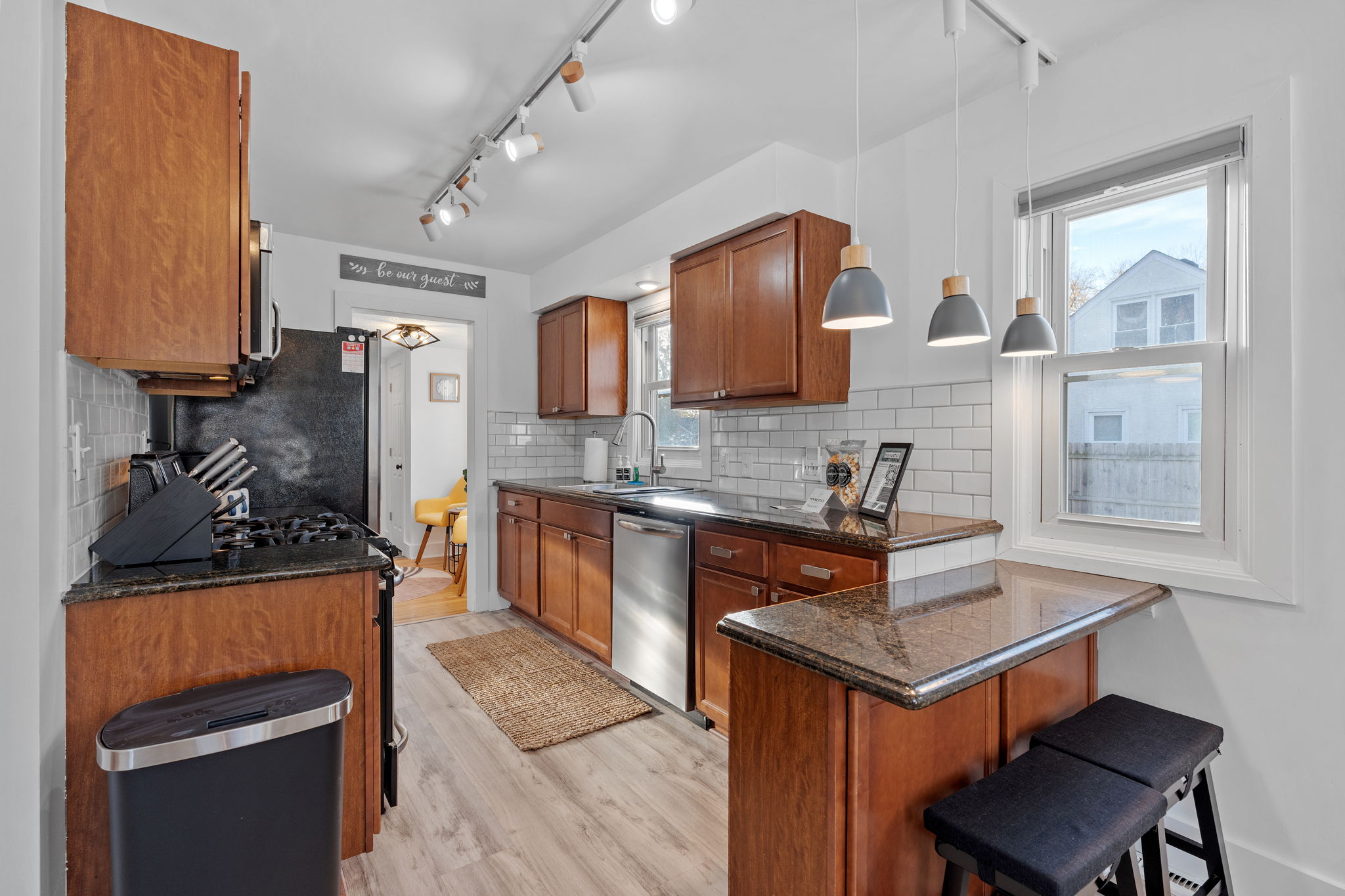 A modern kitchen with warm wood cabinetry and stylish lighting.