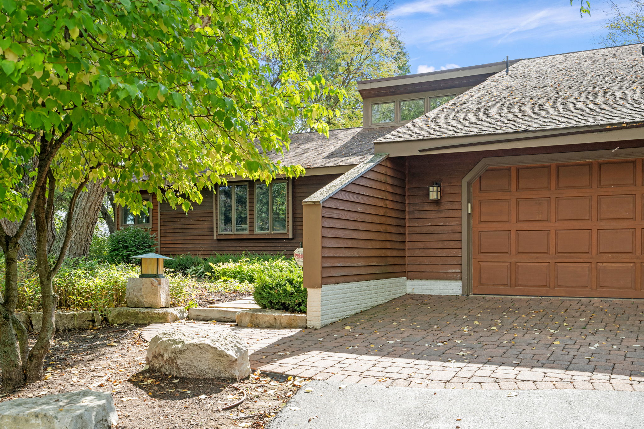 A warm and inviting home with natural surroundings and a well-kept front yard.