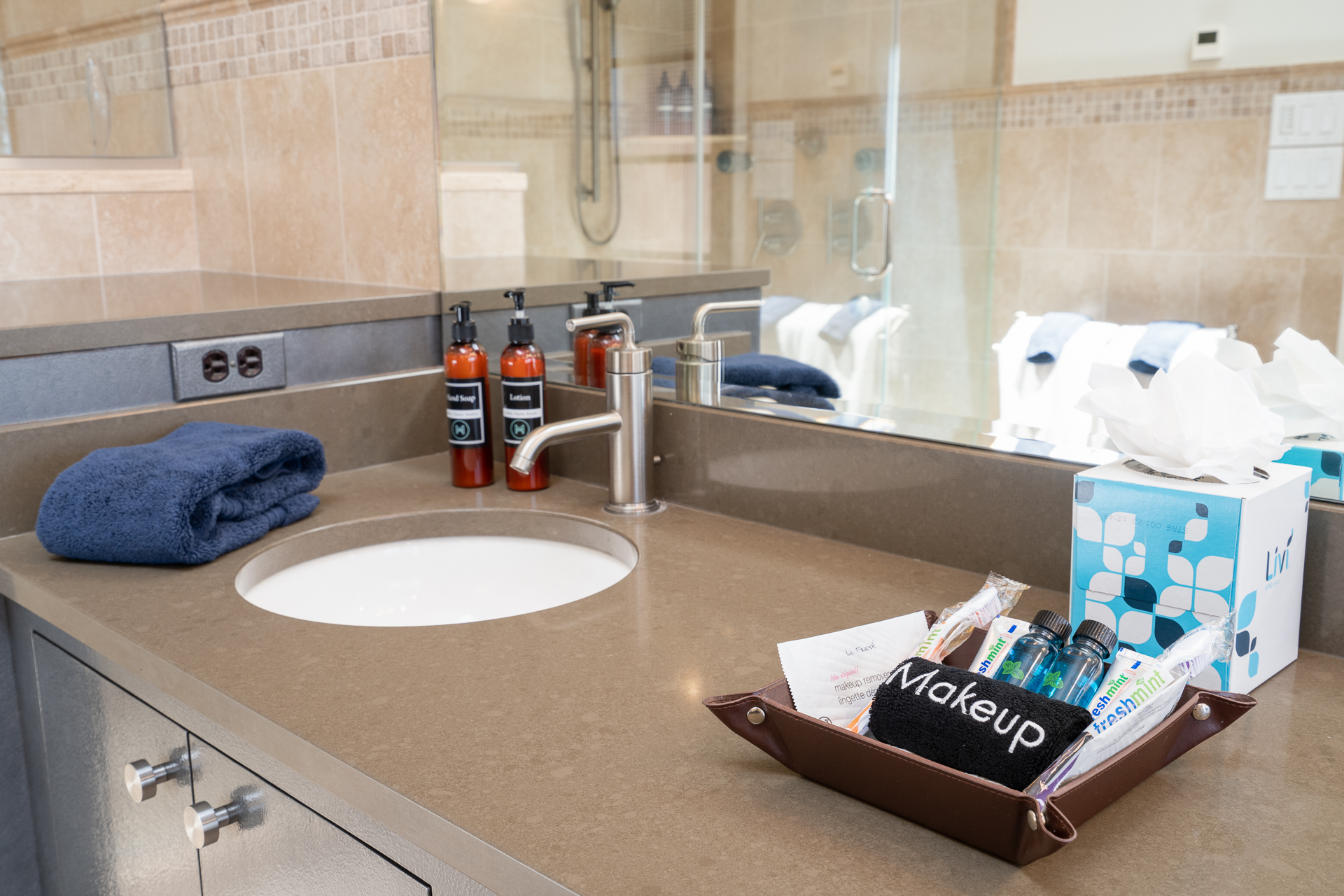 A modern bathroom countertop showcasing arranged toiletries and amenities.