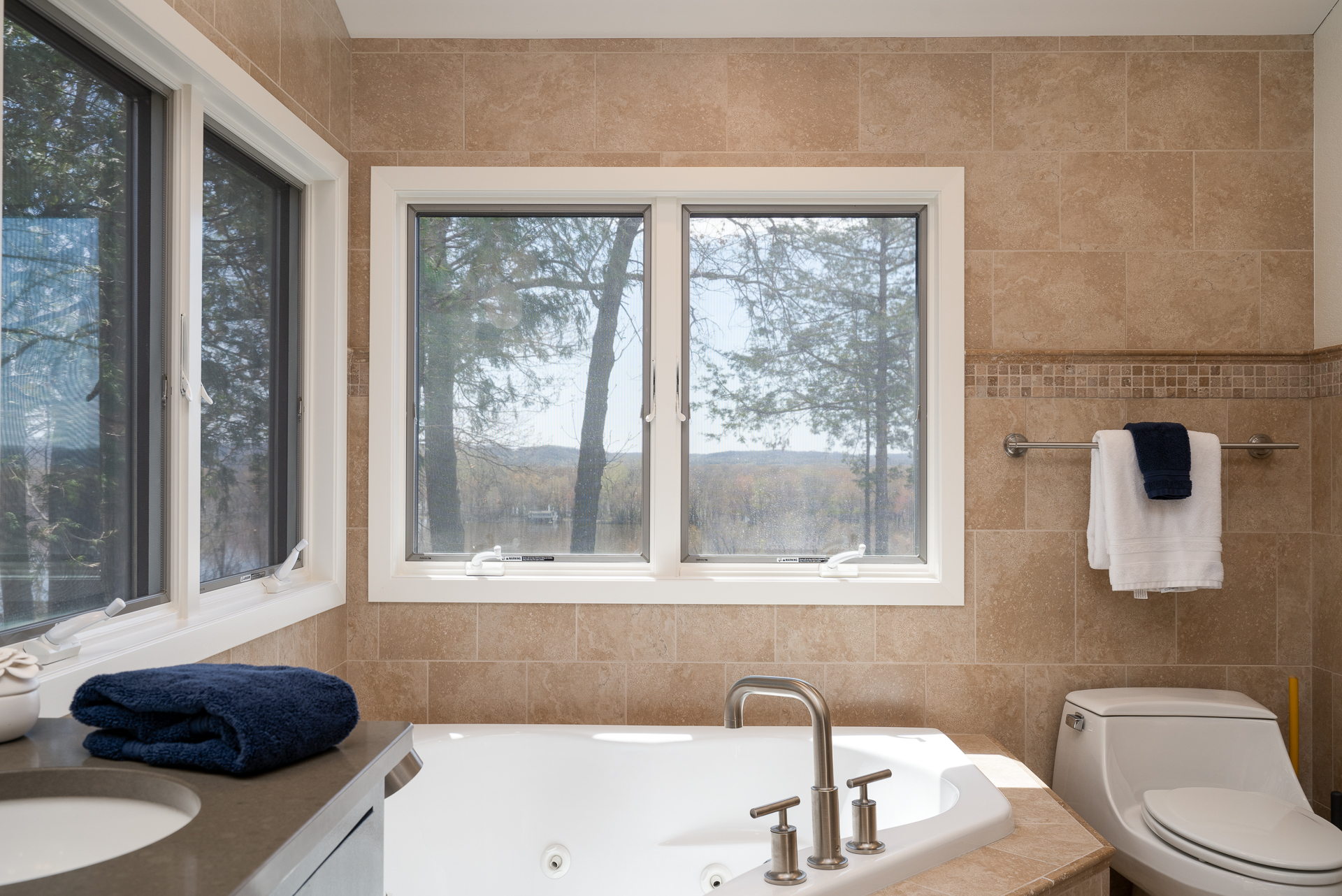 A serene bathroom featuring a soaking tub and a view of nature.