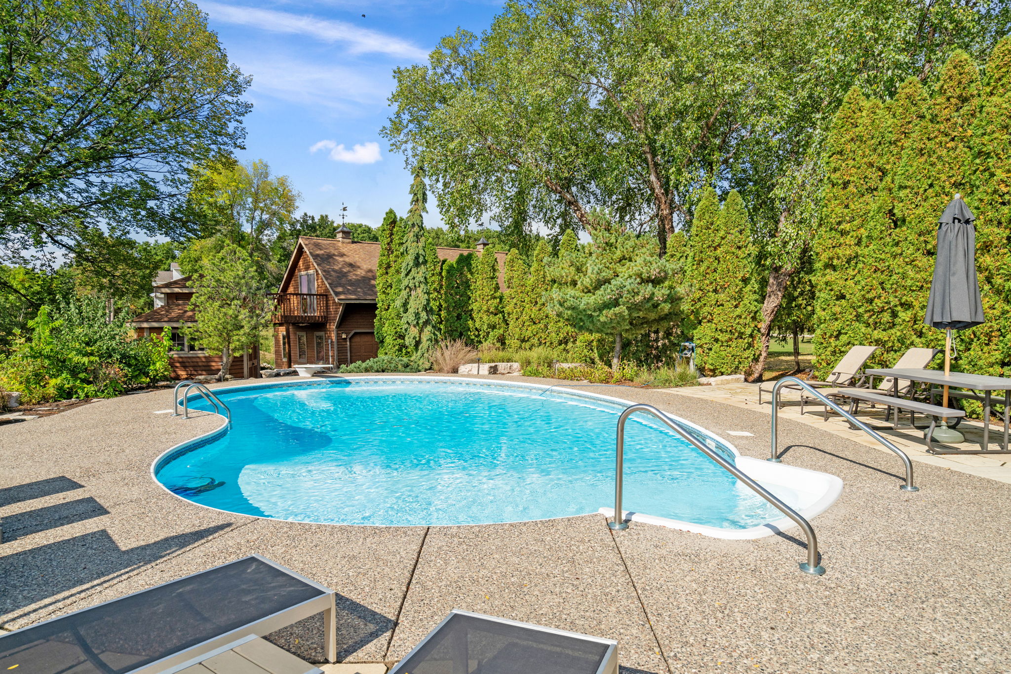 Serene outdoor pool area surrounded by lush greenery.