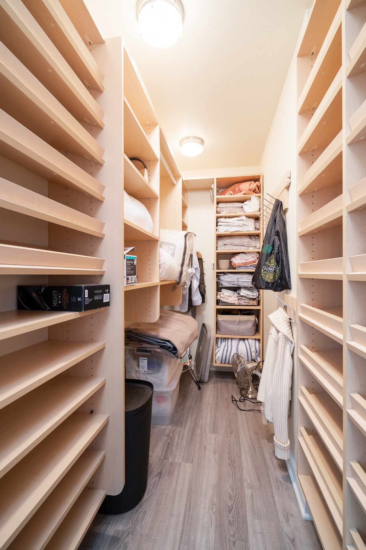 Organized closet with wooden shelving and neatly arranged linens.