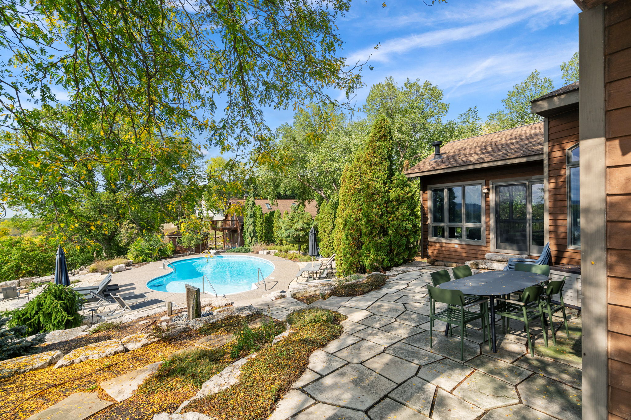 A beautiful outdoor pool area surrounded by lush greenery, perfect for relaxation.