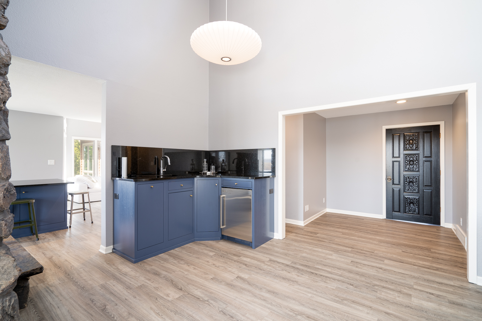 Modern kitchen with navy blue cabinets and a stylish entryway.