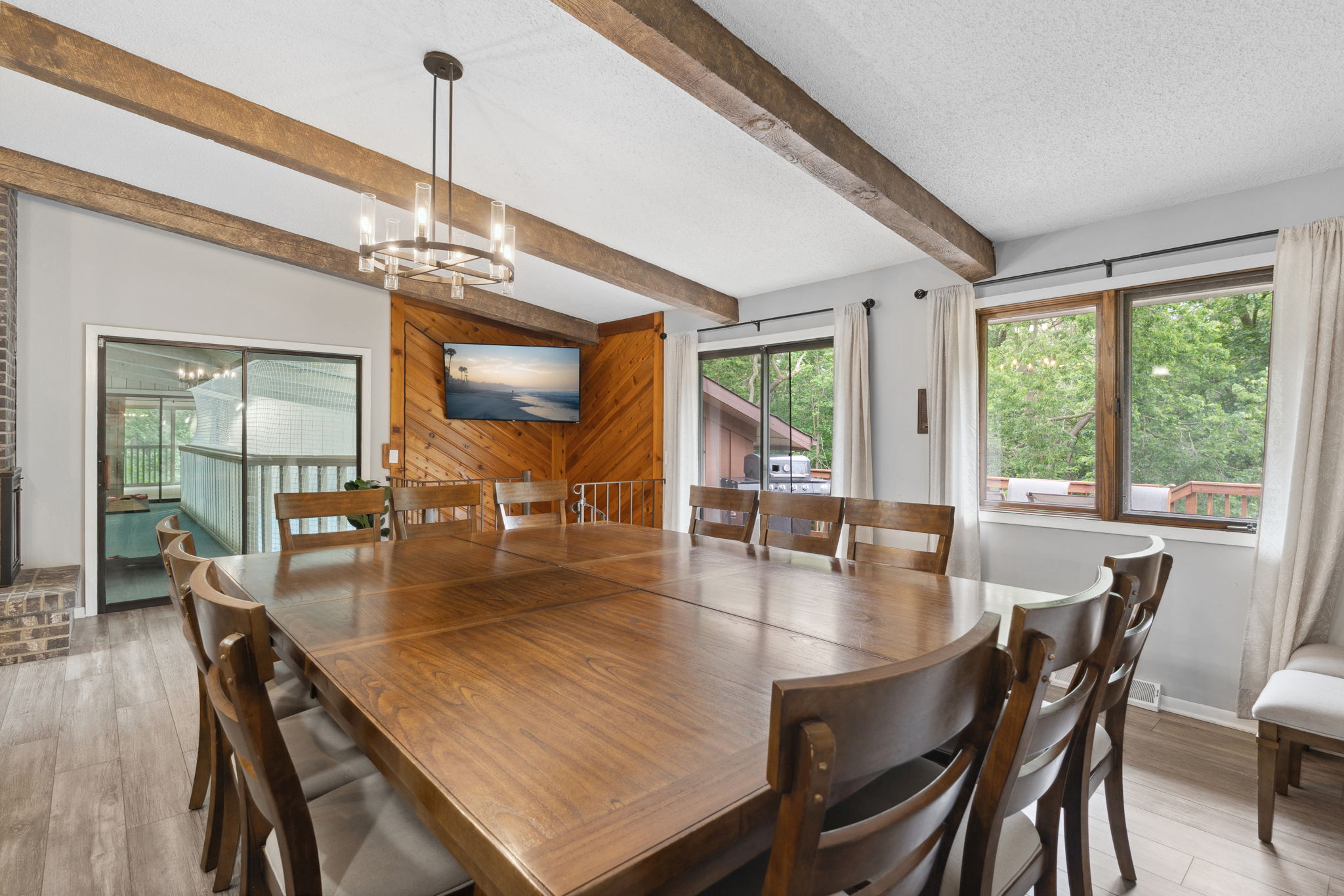 A warm and inviting dining area with a large wooden table and modern chandelier.