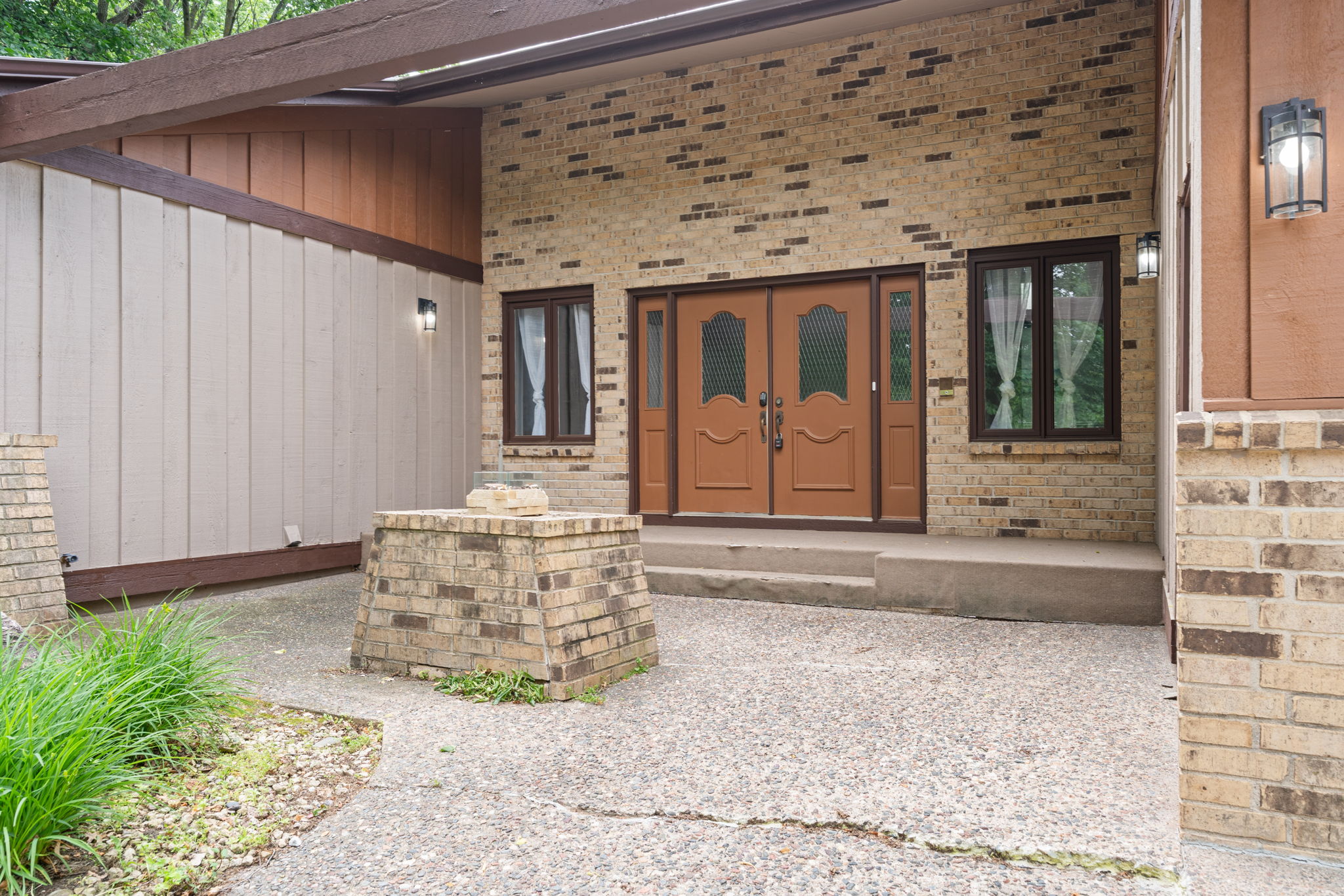 Welcoming front entrance with elegant double doors and rustic stone features.