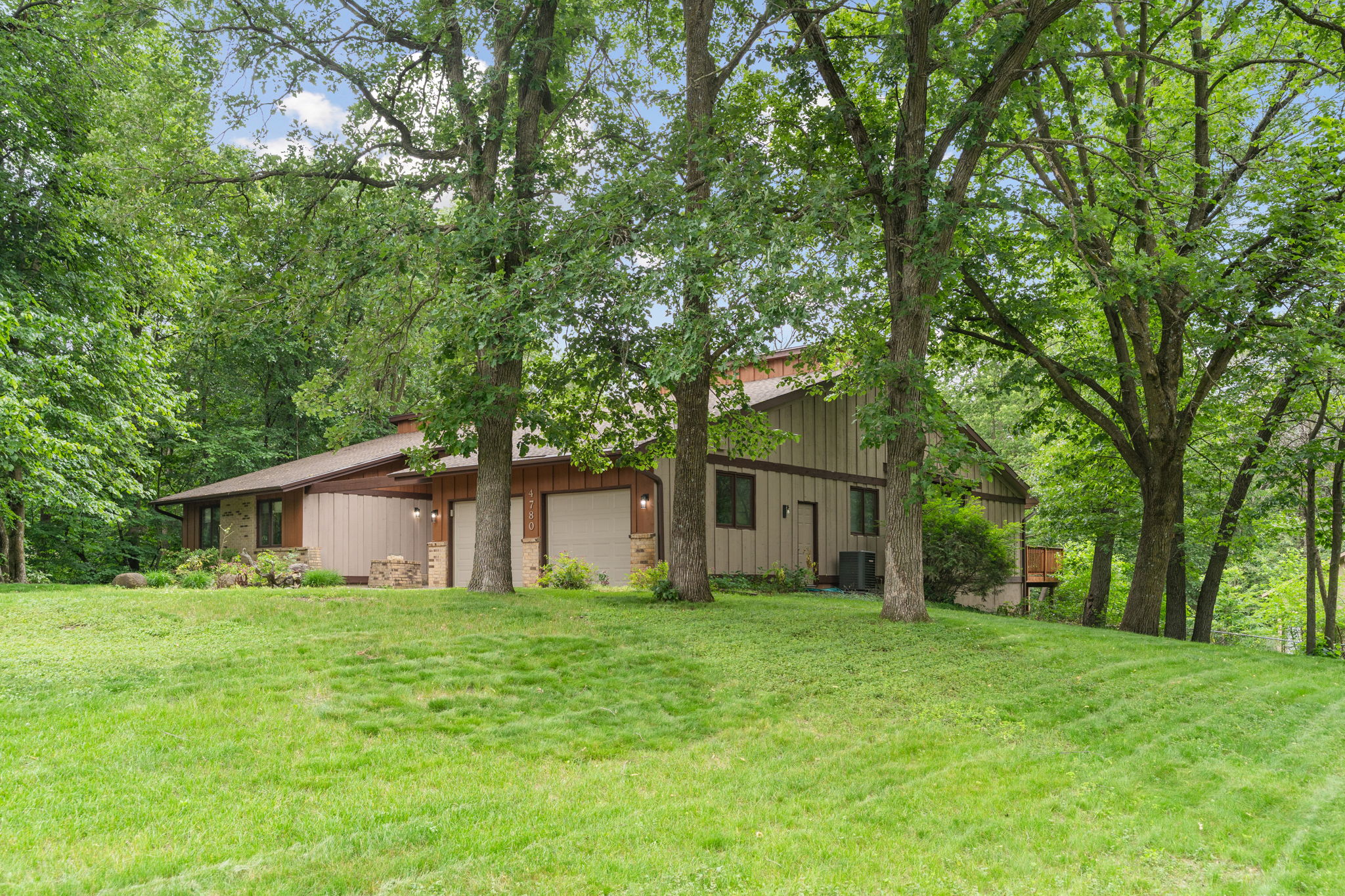 A contemporary home surrounded by lush greenery, offering a serene atmosphere.