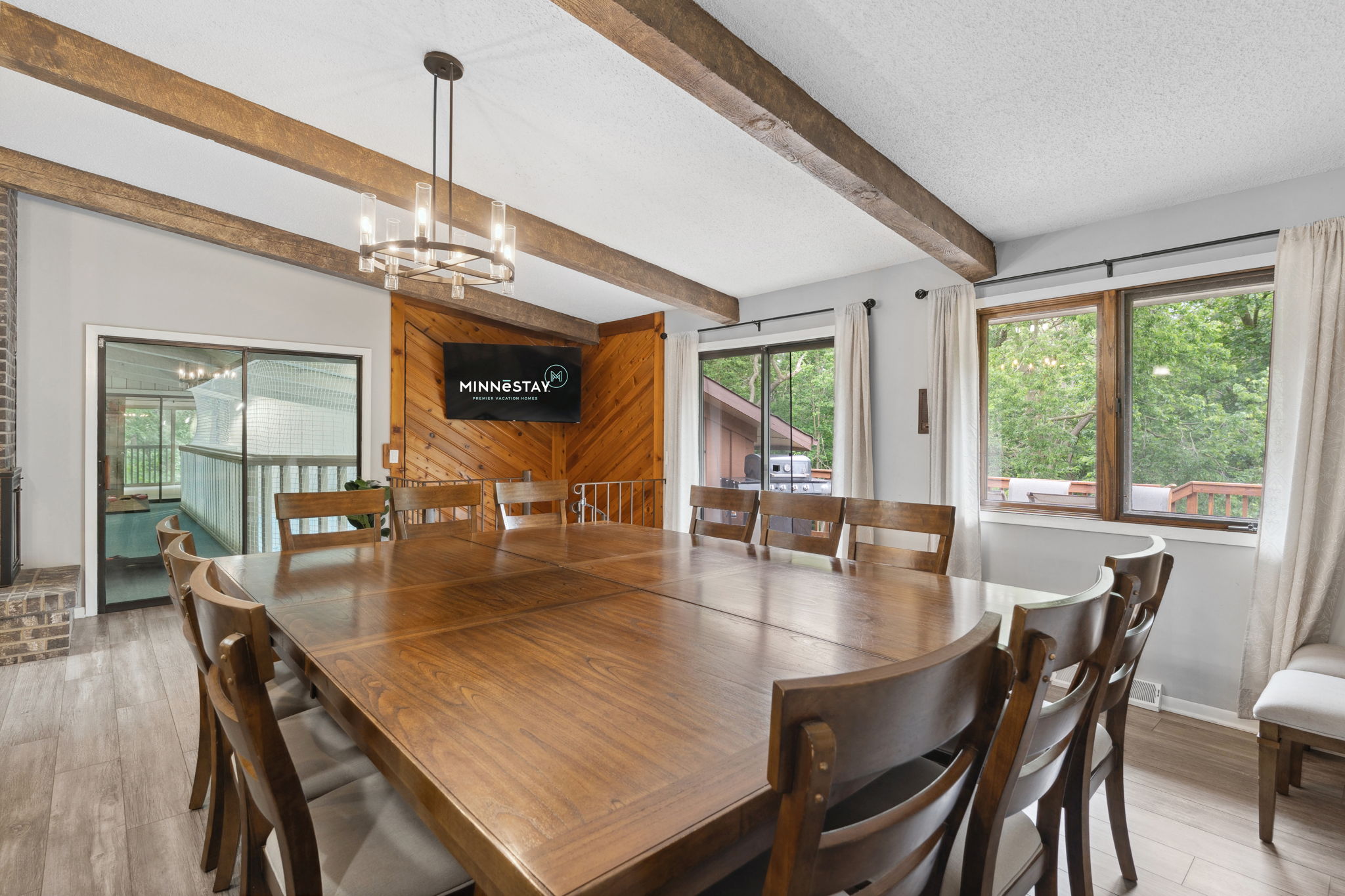 A cozy dining area featuring a large wooden table, rustic decor, and modern amenities.